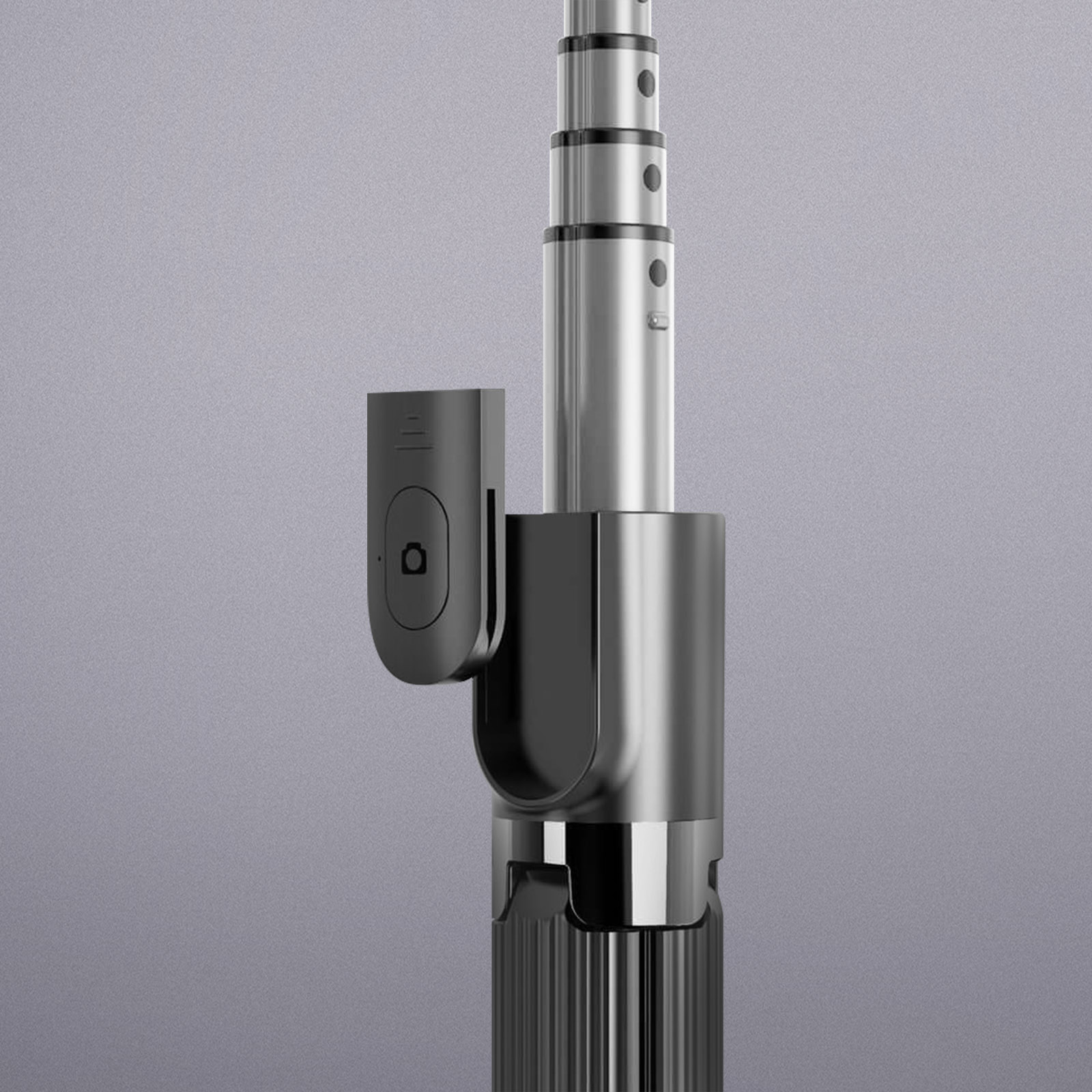 Un primo piano di un selfie stick nero e argento con un attacco per telecomando.