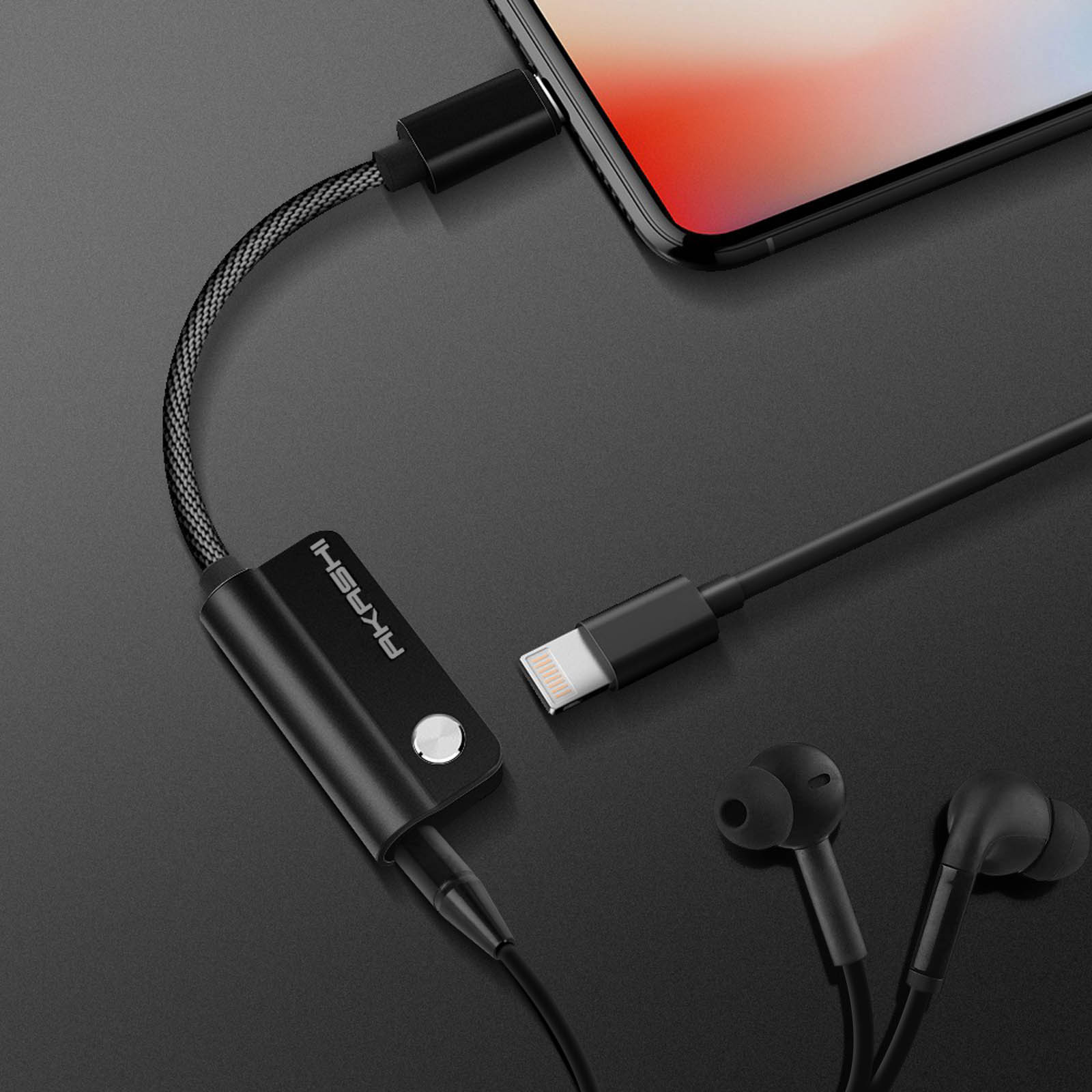 Un adaptateur audio noir avec un câble, des écouteurs et un téléphone.