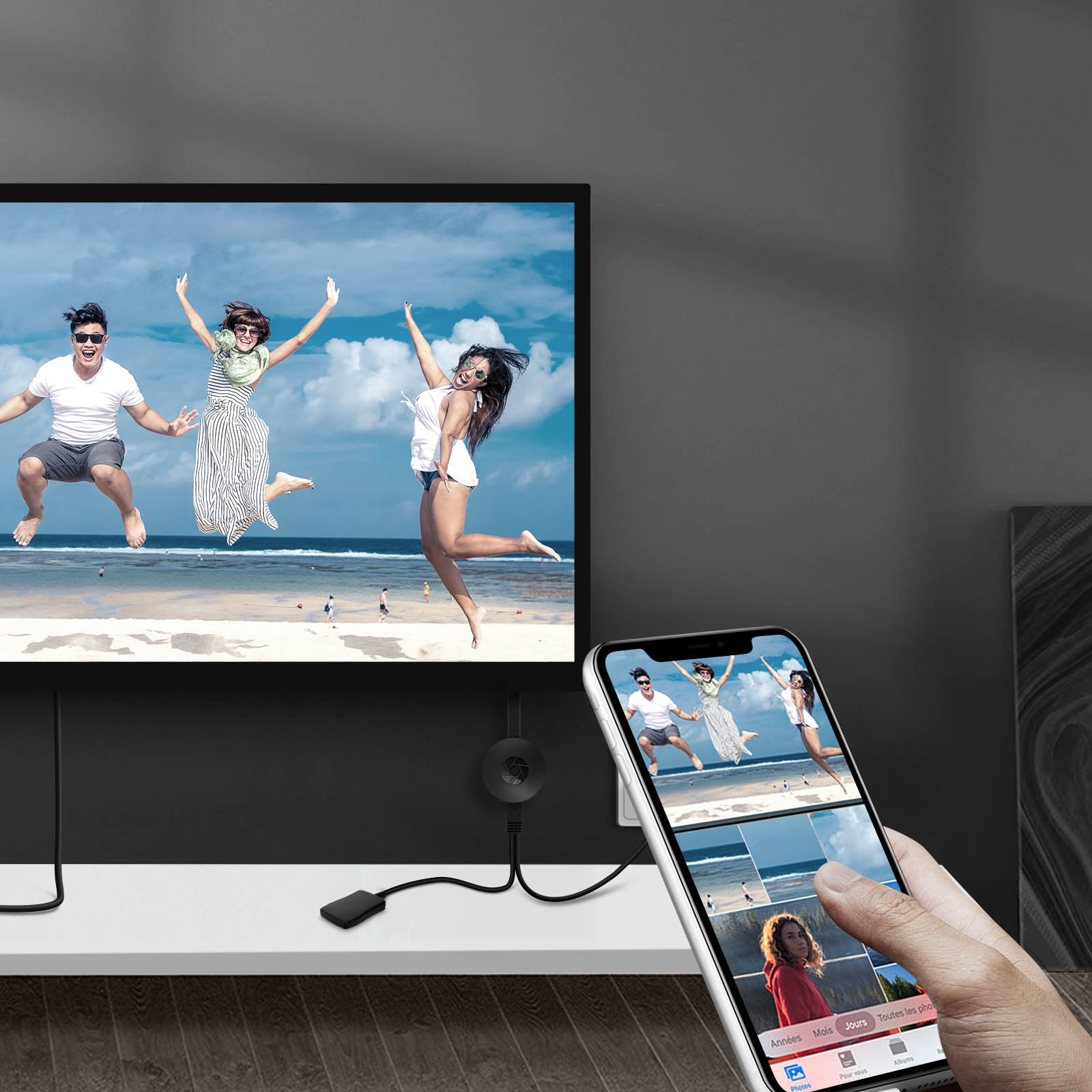 Persone che saltano su uno schermo TV, telefono che mostra la stessa immagine, con un dispositivo nero.