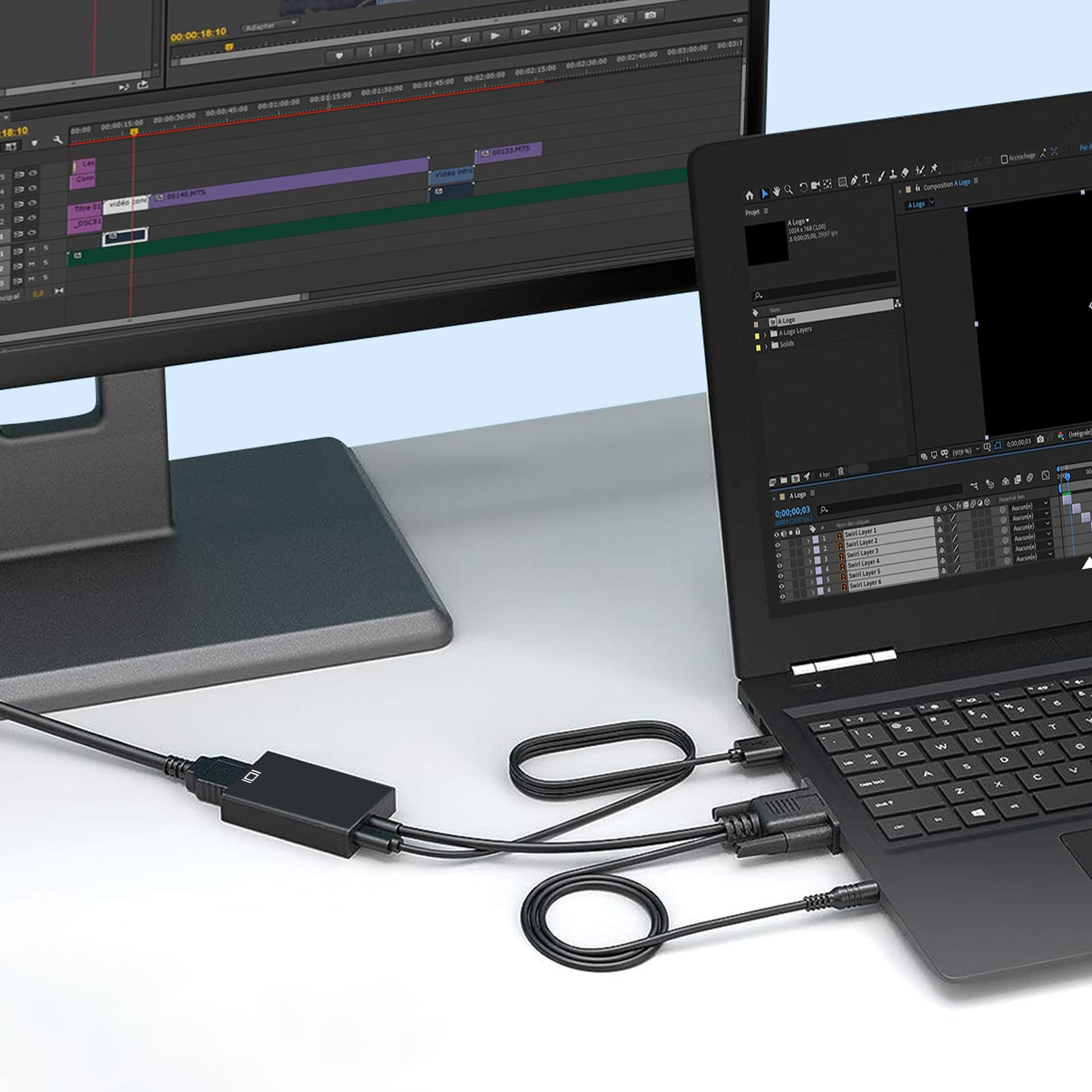 Laptop collegato a un monitor. Sono collegati anche cavi e una scatola nera.