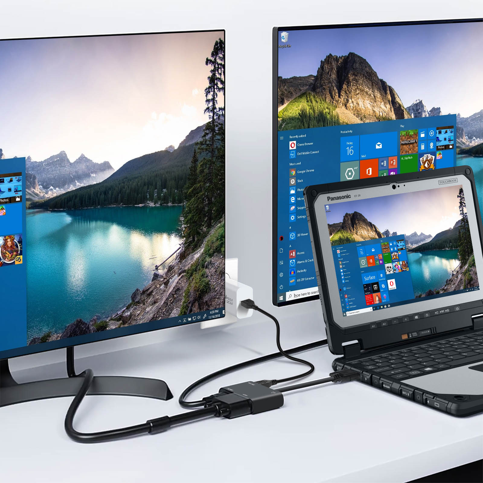 Due monitor per computer e un laptop collegati. Un monitor mostra un'interfaccia blu.