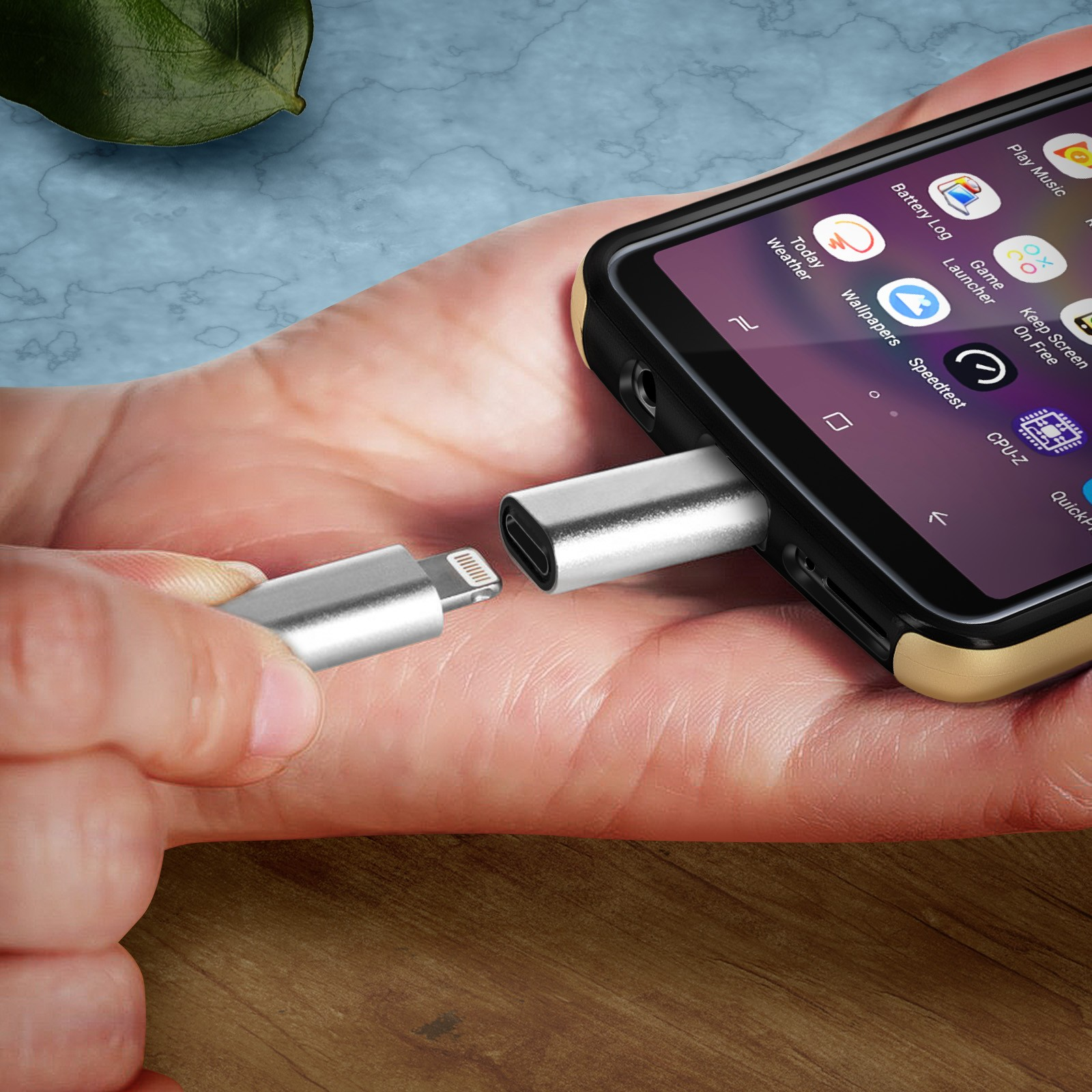 Hand, die einen silbernen Adapter mit Lightning-Anschluss in ein Telefon einführt.