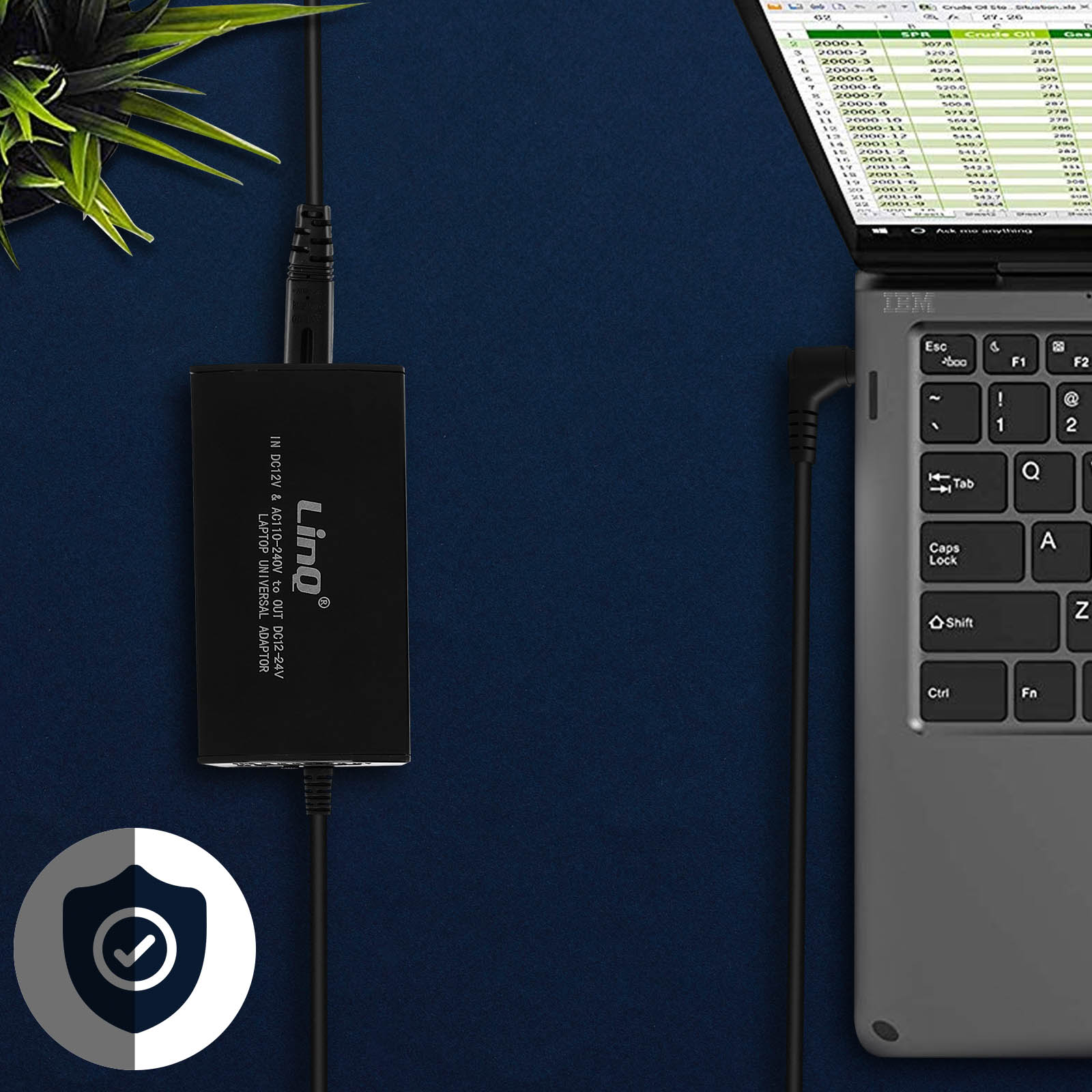 Adaptador de corriente negro conectado a una computadora portátil y a una toma de corriente. Icono de escudo en primer plano.