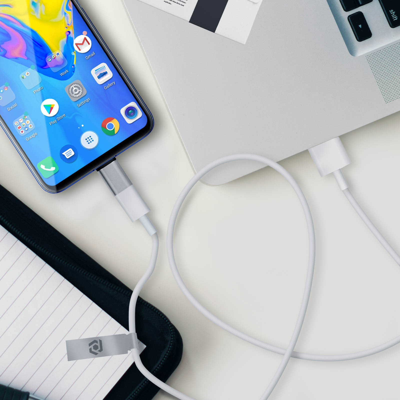 Smartphone collegato a un laptop tramite un cavo USB-C. Il telefono è su un tavolo.