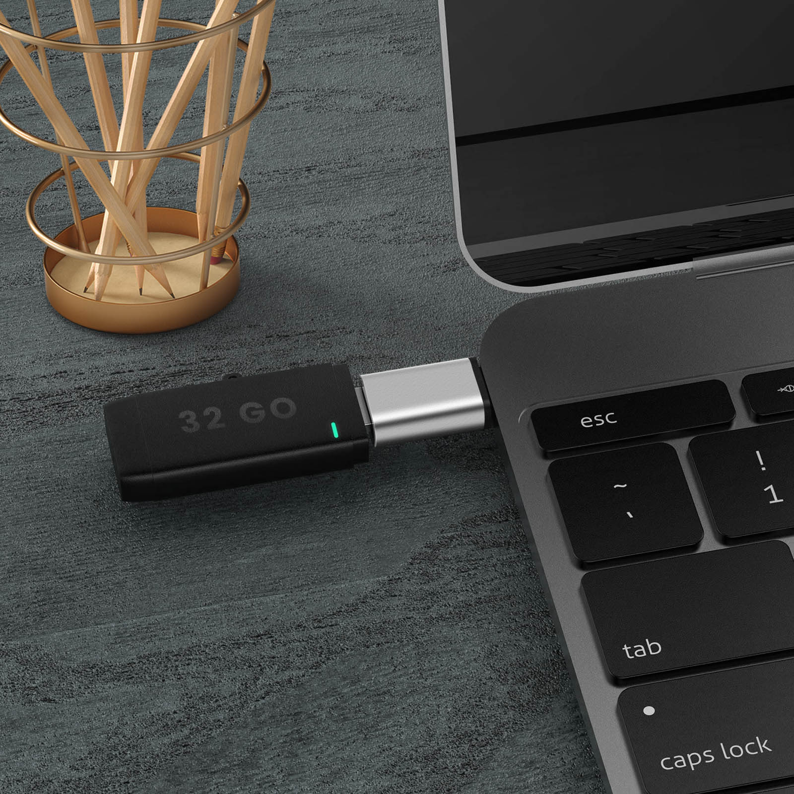 Chiavetta USB-C nera collegata a un laptop. Argento e luce verde.