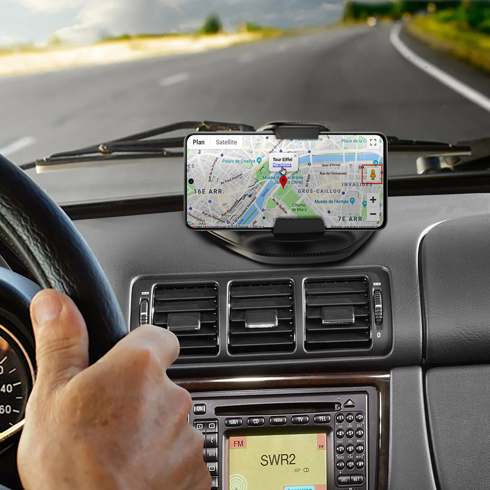 Interni auto con telefono che mostra un'app di navigazione. Cruscotto e volante sono visibili.