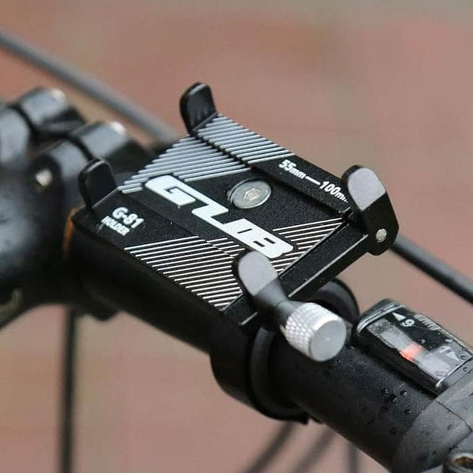 Eine schwarze Telefonhalterung an einem Fahrradlenker. Sie hält ein Telefon und hat Bedienelemente.