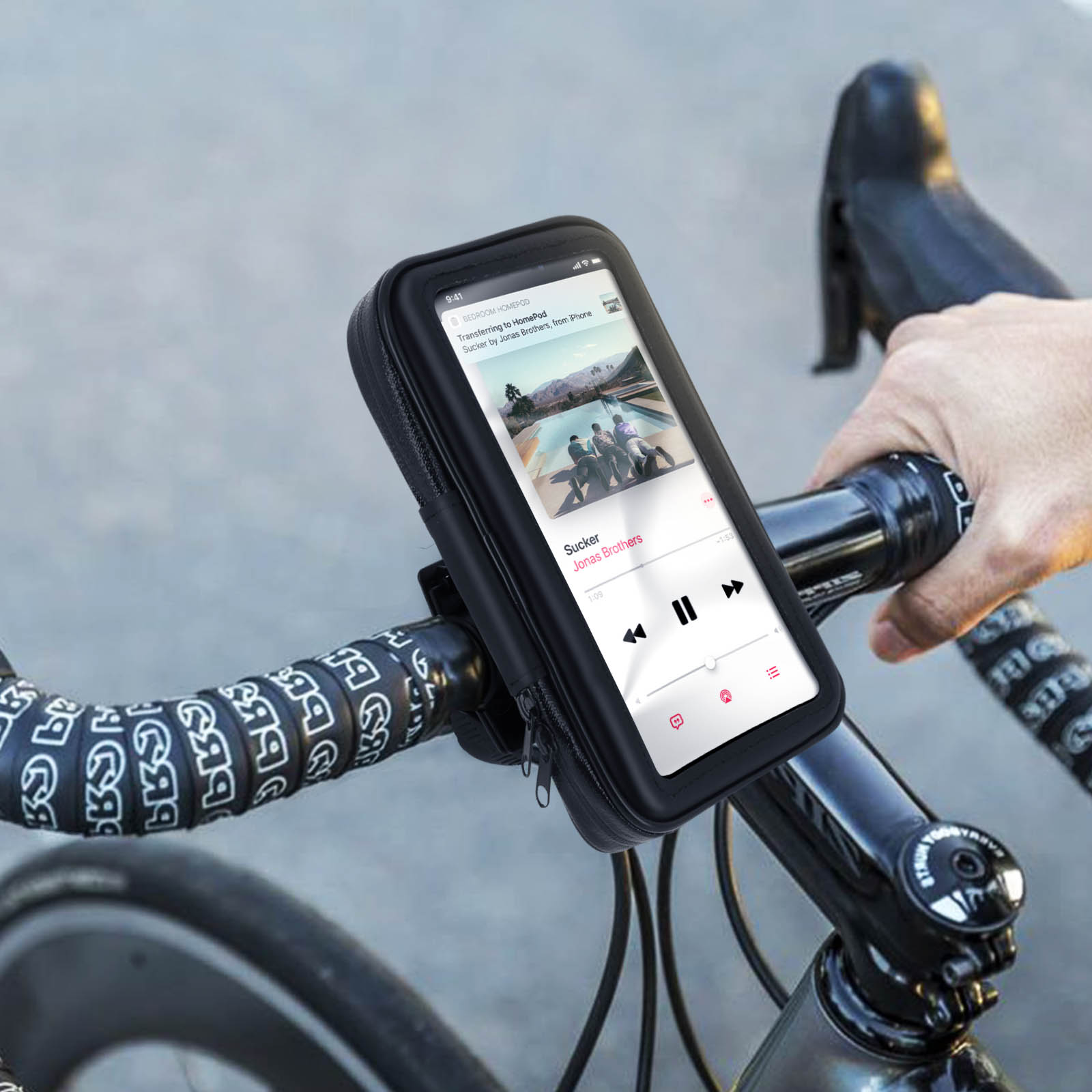 Telefono sul manubrio di una bicicletta. Il telefono è in una custodia nera, che mostra musica.