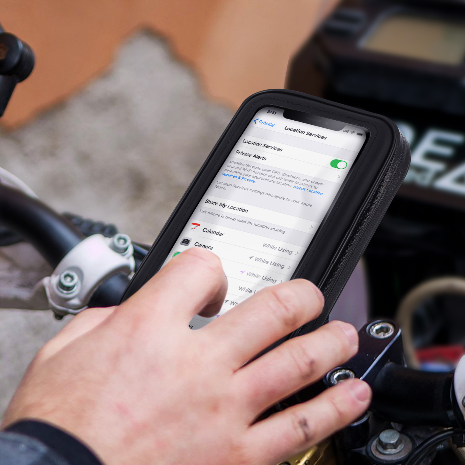 Telefono montato sul manubrio di una moto. Lo schermo mostra le impostazioni dei Servizi di localizzazione.