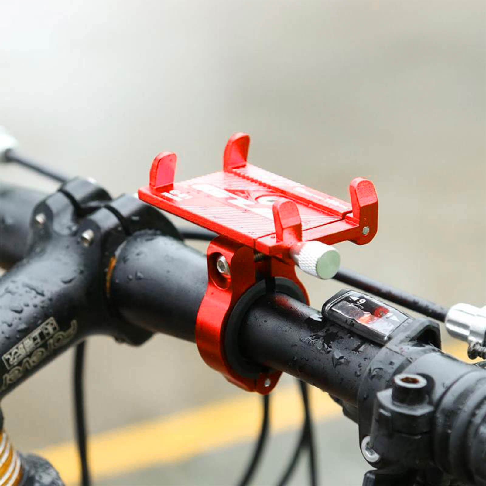 Supporto telefono bici rosso fissato al manubrio nero con regolazione argento.