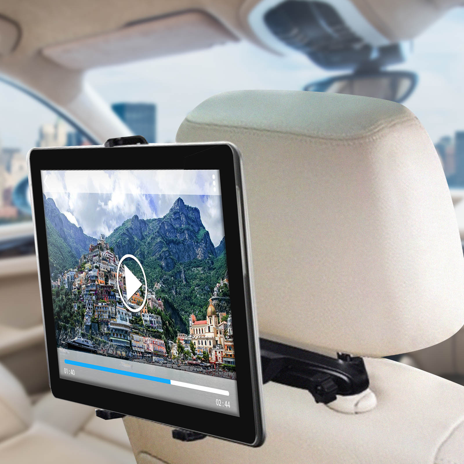 Tablet im Auto, das ein Video einer Küstenstadt mit Play-Button und Fortschrittsbalken anzeigt.