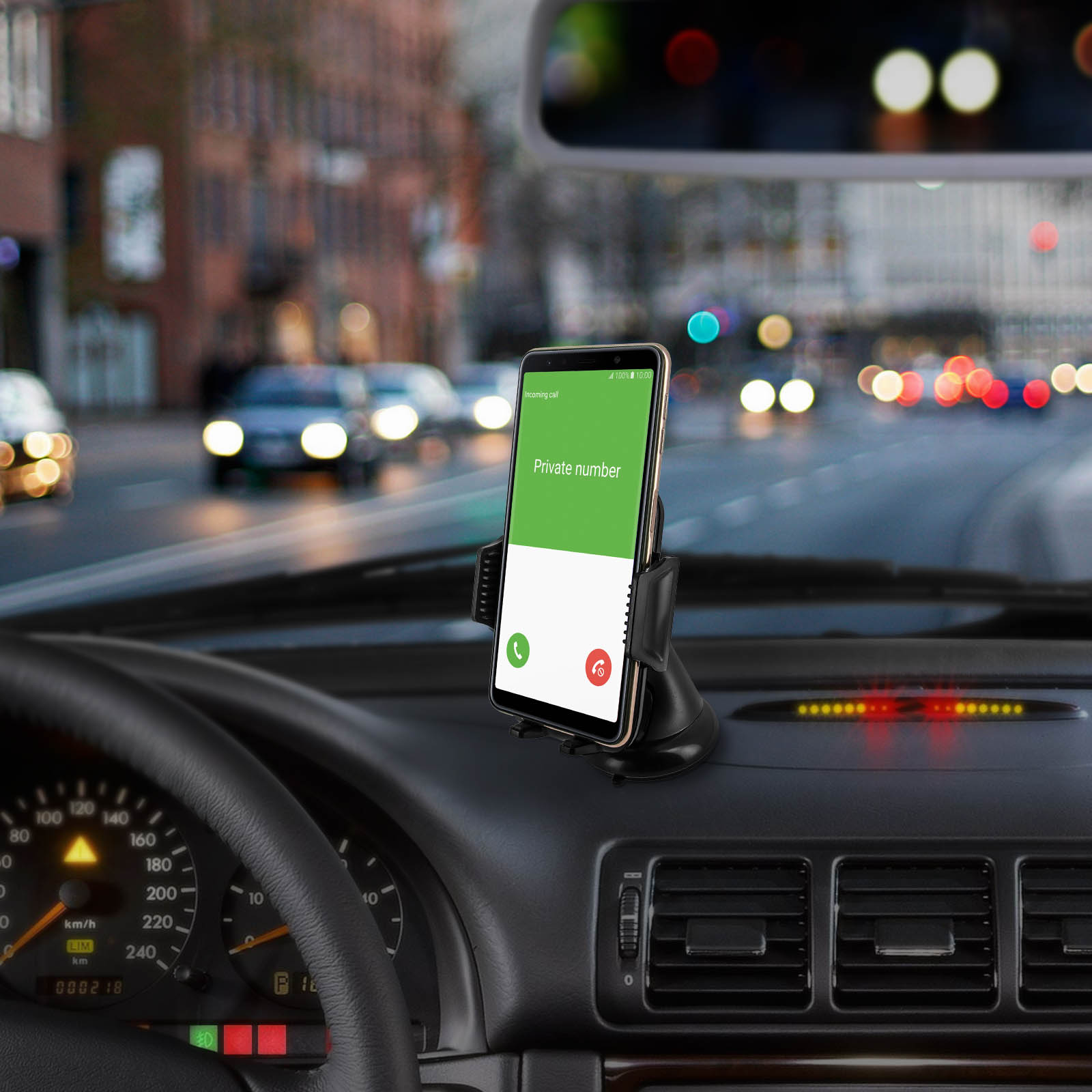 Ein Telefon in einer Autohalterung zeigt einen eingehenden Anruf von einer privaten Nummer an. Der Innenraum des Autos ist sichtbar.