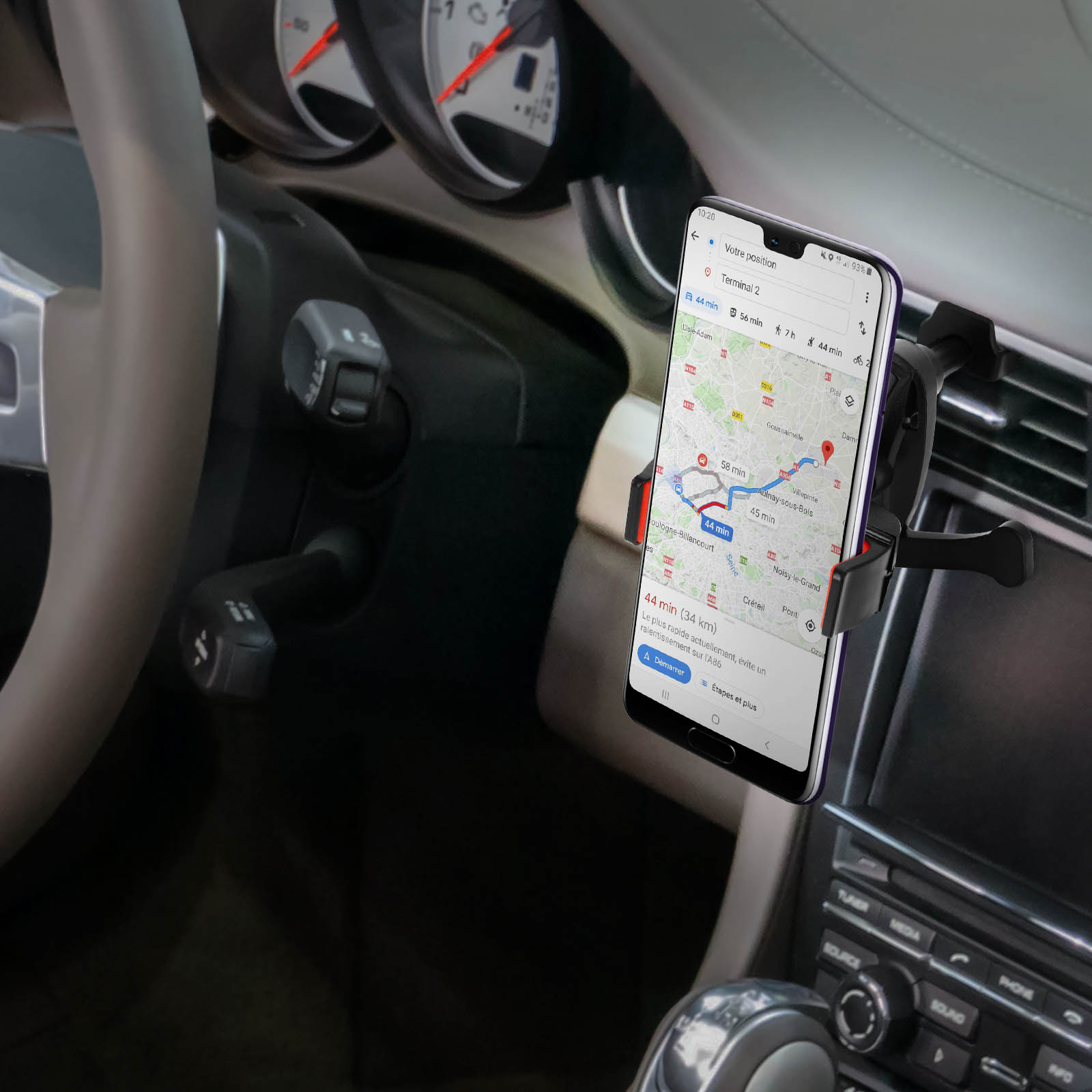 Telefon in Autohalterung mit aktiver Navigations-App. Innendetails des Autos, einschließlich Lenkrad, sichtbar.