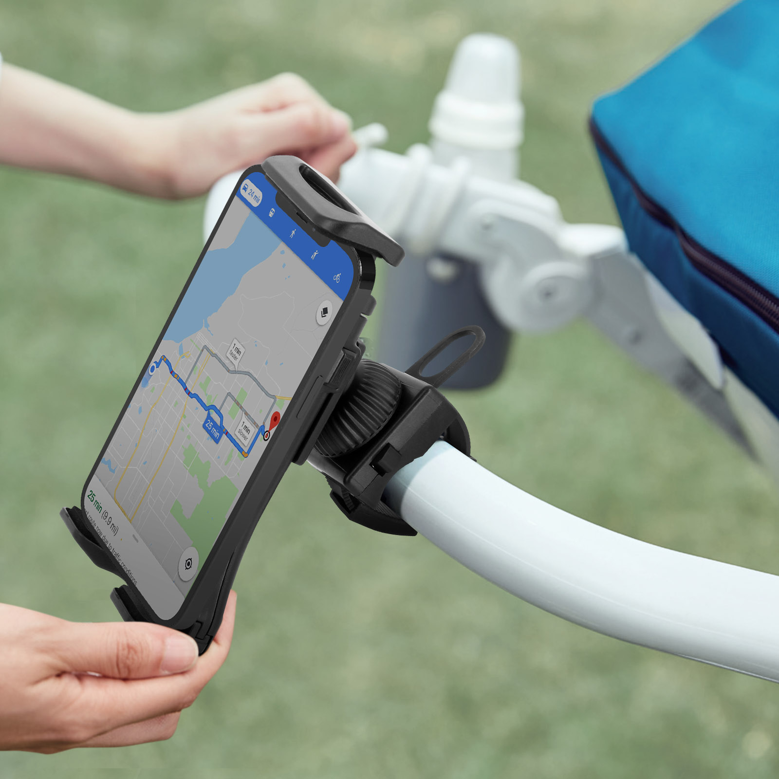 Una persona sostiene un teléfono en un soporte para teléfono sujeto a un asa de cochecito. El teléfono muestra un mapa.