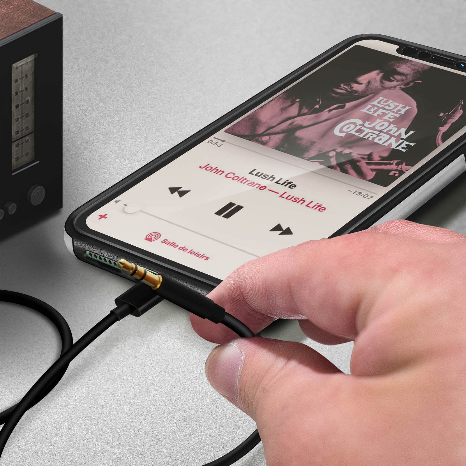 Mano sosteniendo un teléfono con un cable conectado. El teléfono está reproduciendo música.