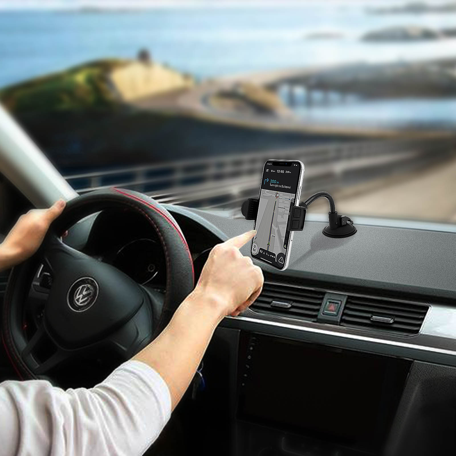 Die Hand einer Person zeigt auf ein Telefon im Auto. Das Telefon zeigt eine Karte. Das Auto hat ein Armaturenbrett.