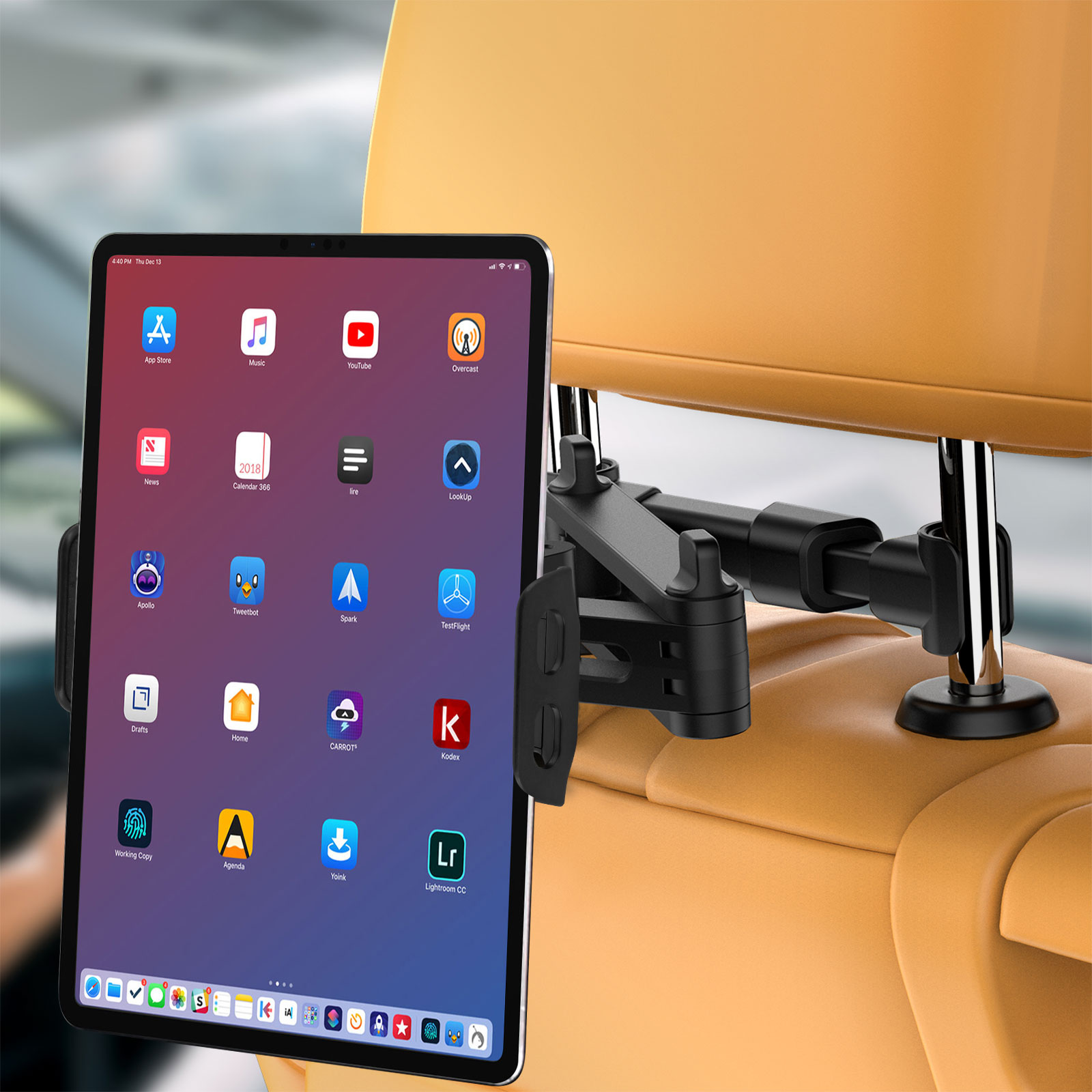 Tableta mostrando iconos de apps, montada en reposacabezas de coche. Asientos beige.