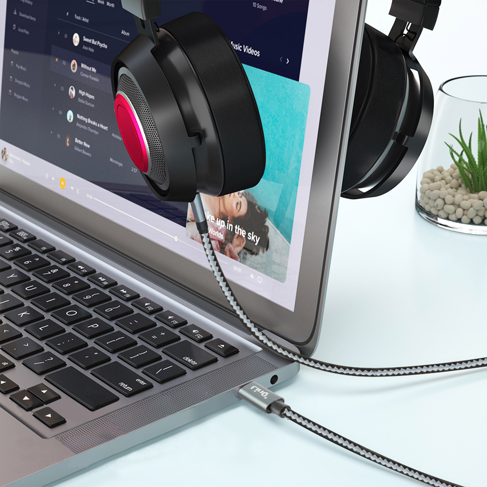 Laptop con auriculares enchufados, mostrando una interfaz de reproductor de música.