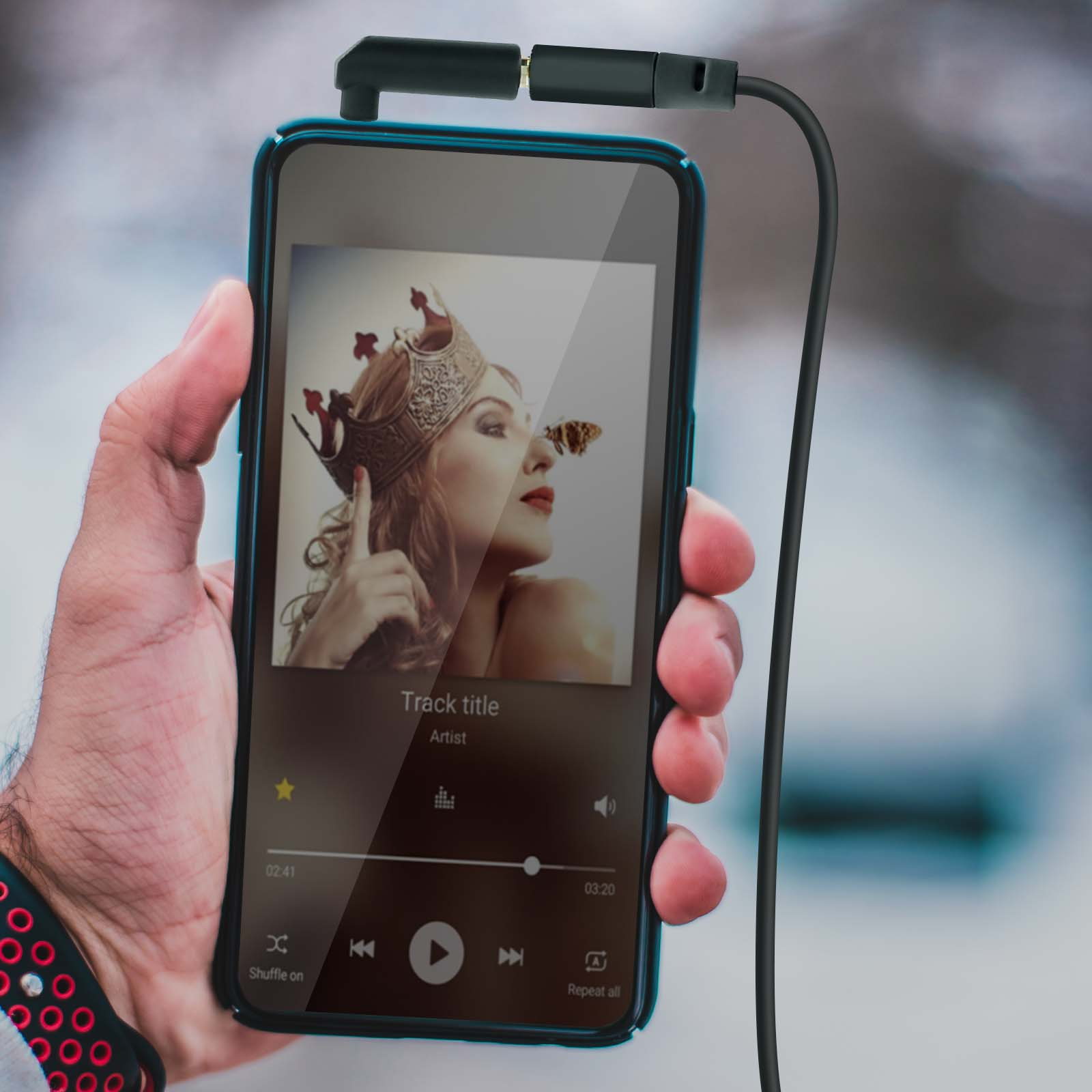 Un smartphone con una interfaz de música reproduciendo una canción con la imagen de una mujer, auriculares conectados.