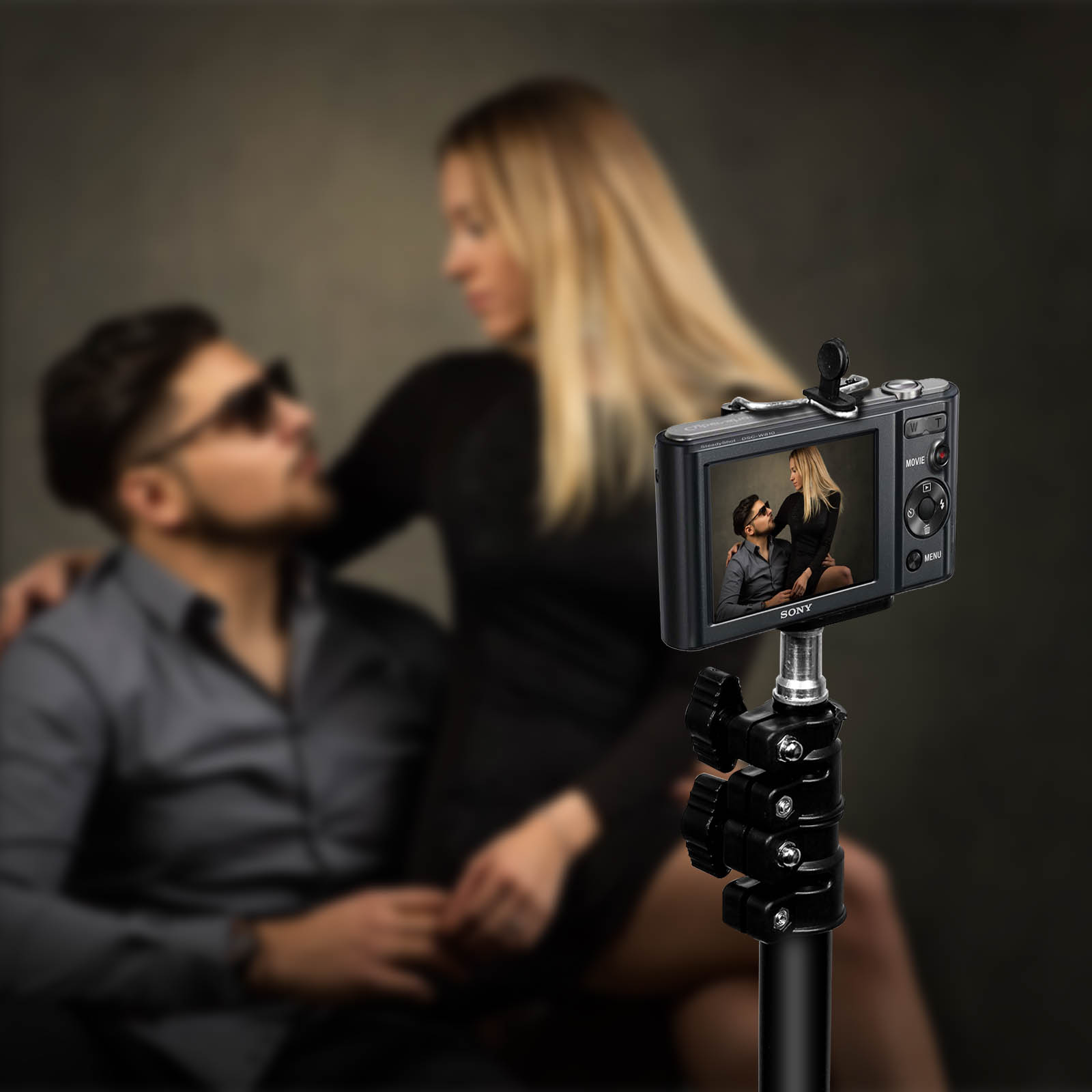 Una cámara en un soporte está filmando a una pareja. La pareja está desenfocada.