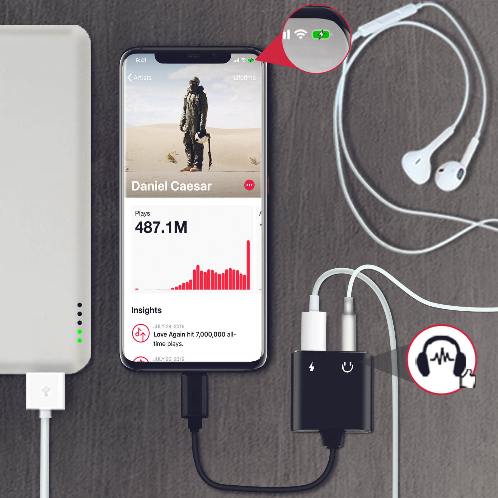 Smartphone zeigt Musik-App-Bildschirm. Kopfhörer und Ladegerät sind angeschlossen.