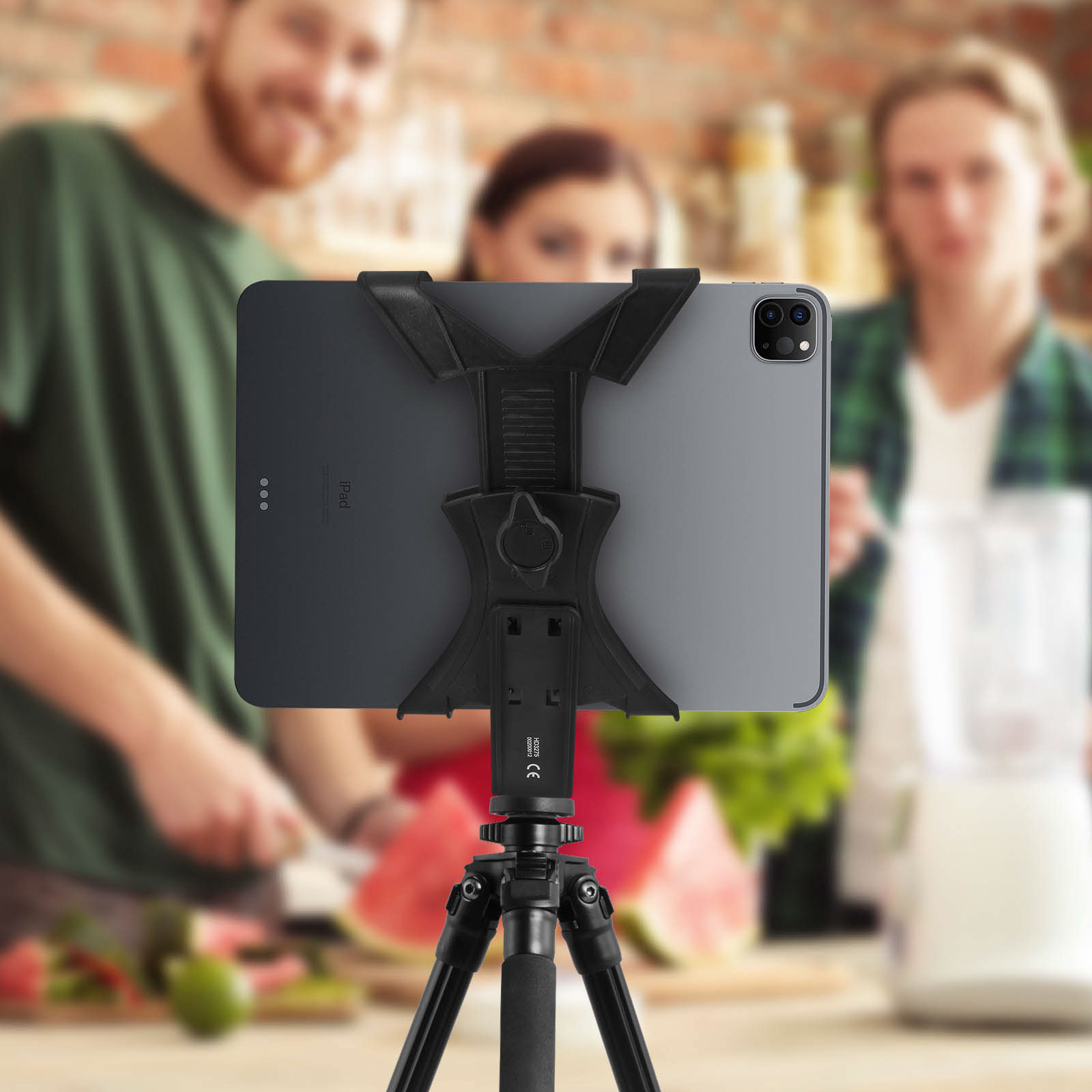 Tablet su un treppiede in cucina. Due persone sfocate sullo sfondo.