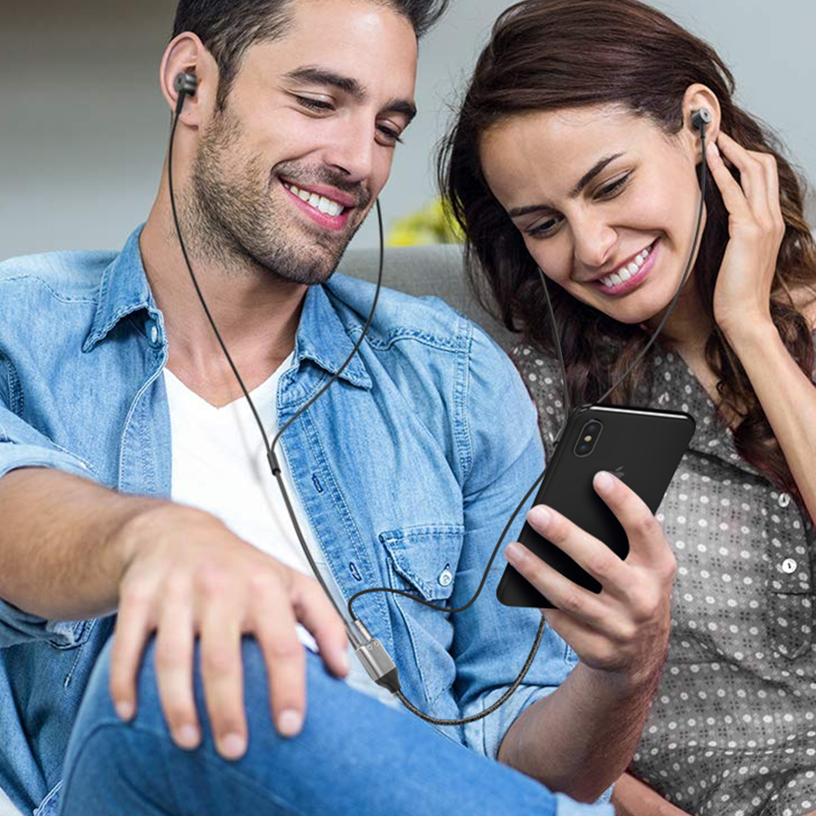 Ein Paar hört Musik mit Kopfhörern, die mit einem Telefon verbunden sind.