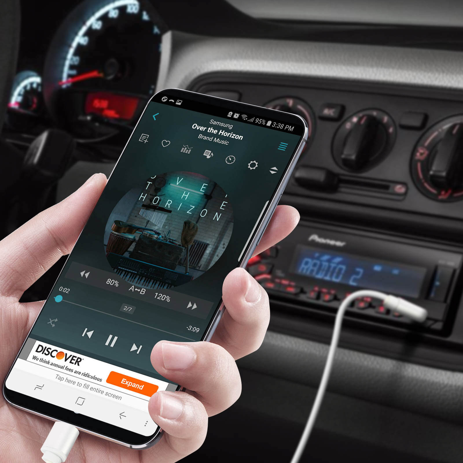 Una mano sosteniendo un smartphone reproduciendo música en un coche.