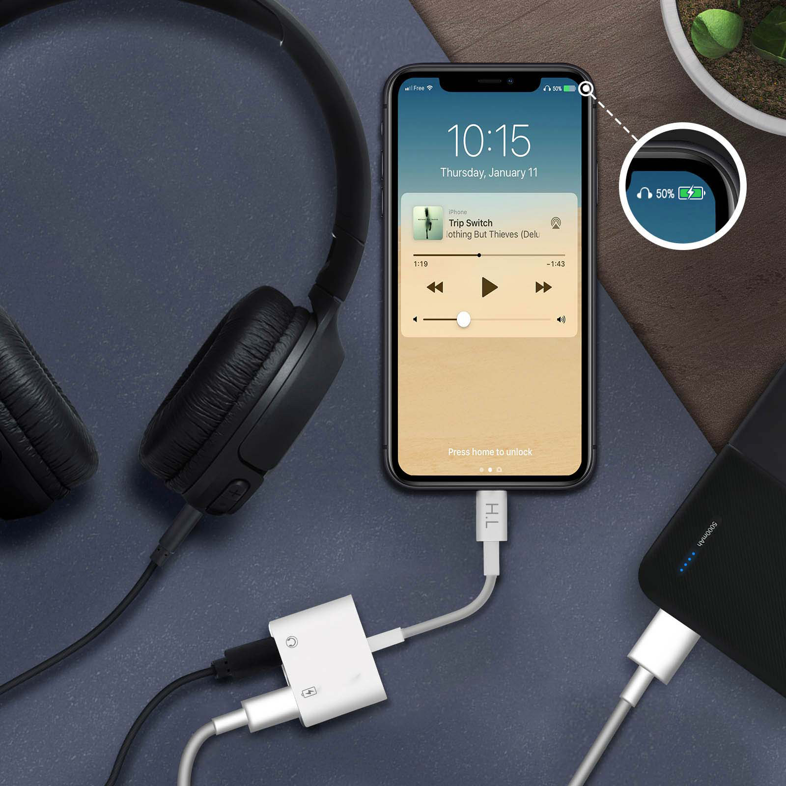 Un téléphone affiche une interface de lecteur de musique. Un casque et un chargeur sont connectés au téléphone.