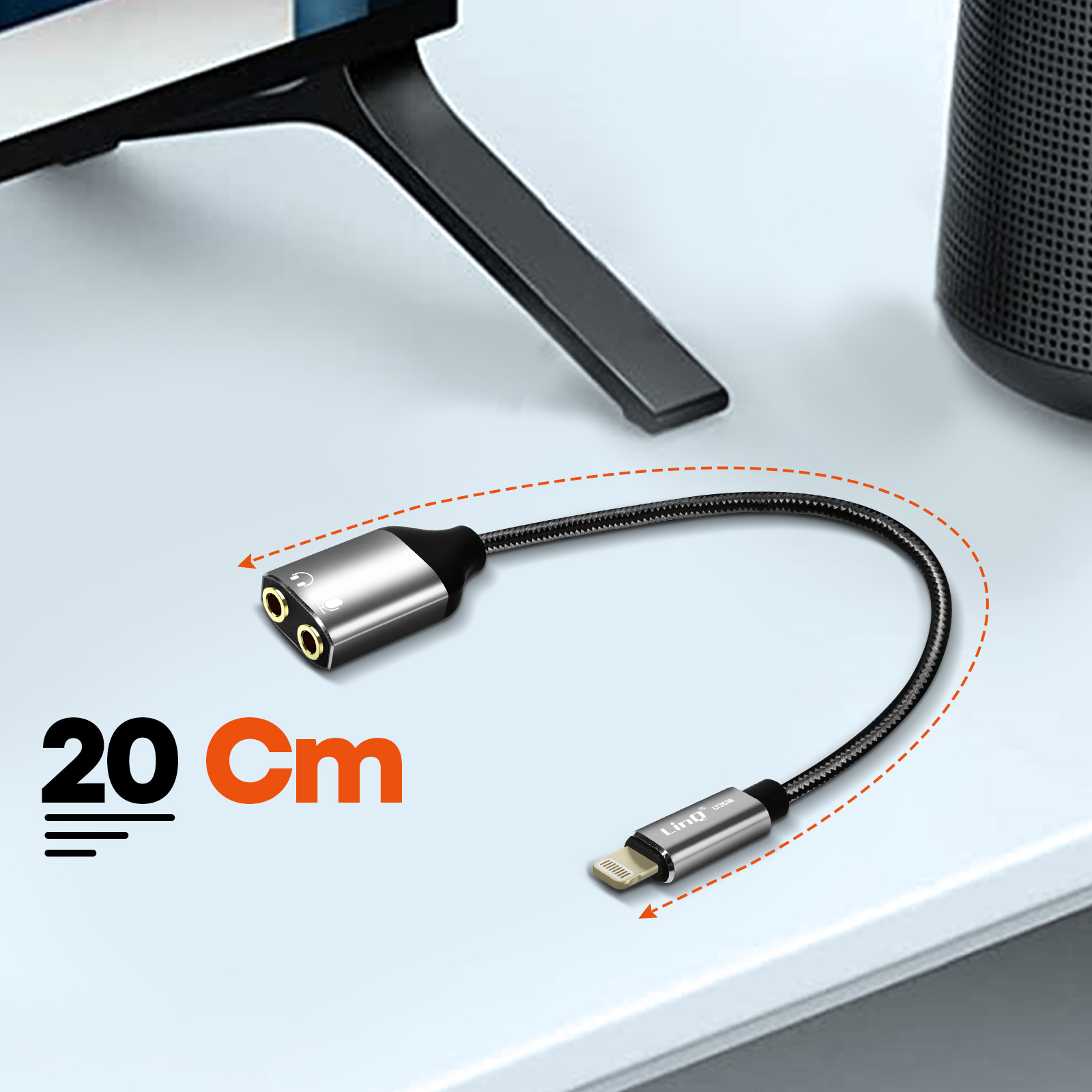 Ein silber-schwarzer Audioadapter mit schwarzem Kabel hat eine 20 cm Messgrafik auf einem weißen Schreibtisch.