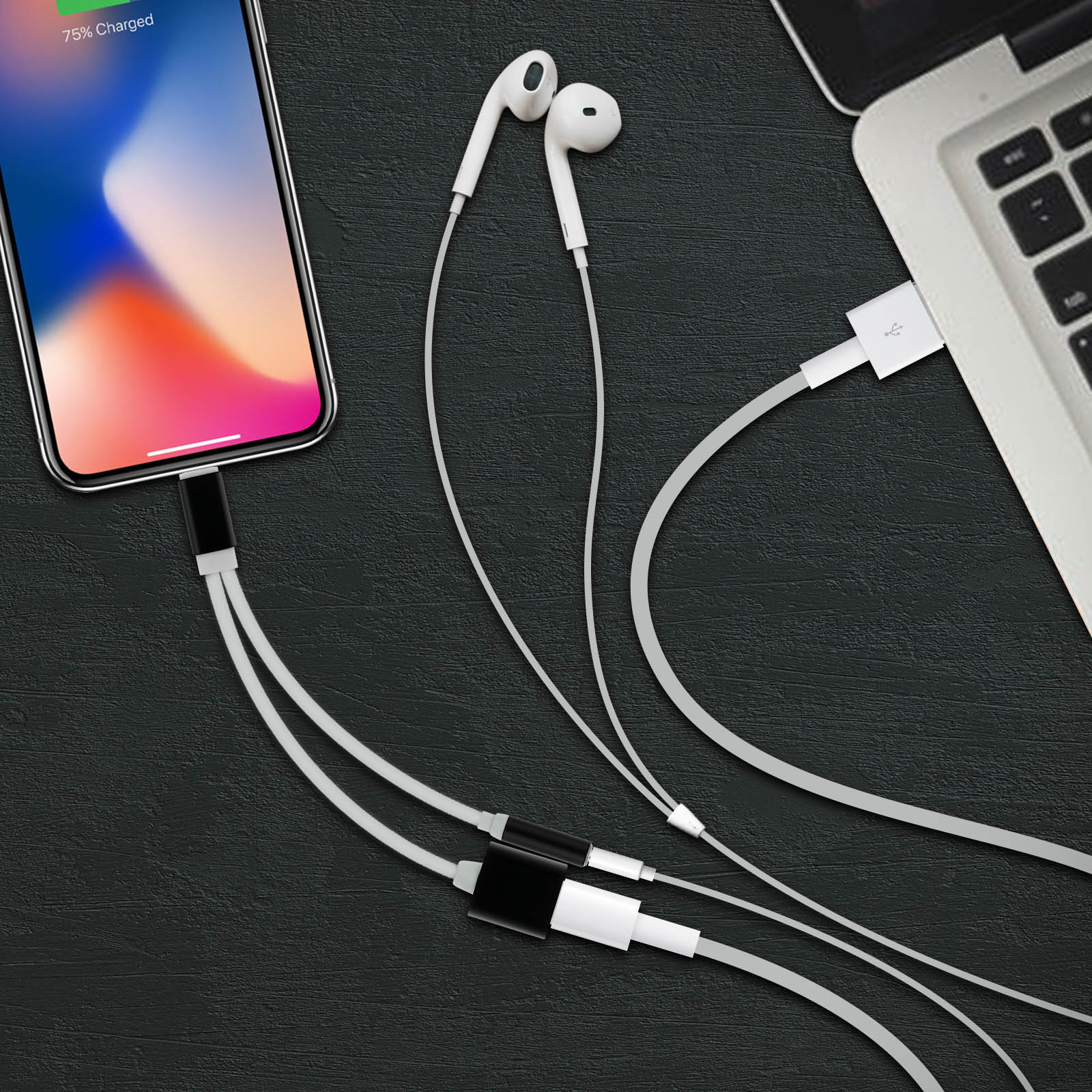 Teléfono con auriculares y cargador conectado a un portátil.