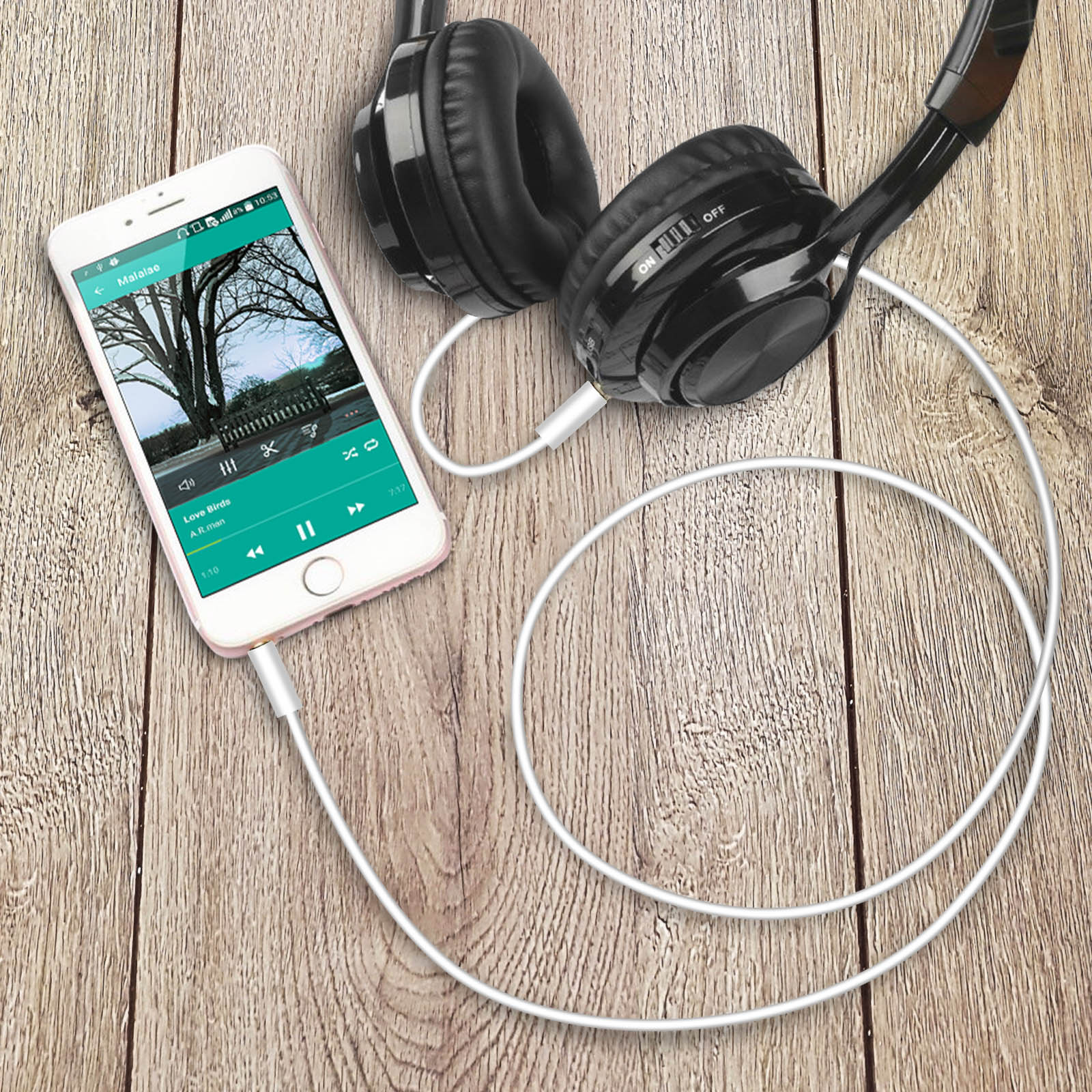 Un telefono che riproduce musica collegato a cuffie su una superficie di legno.
