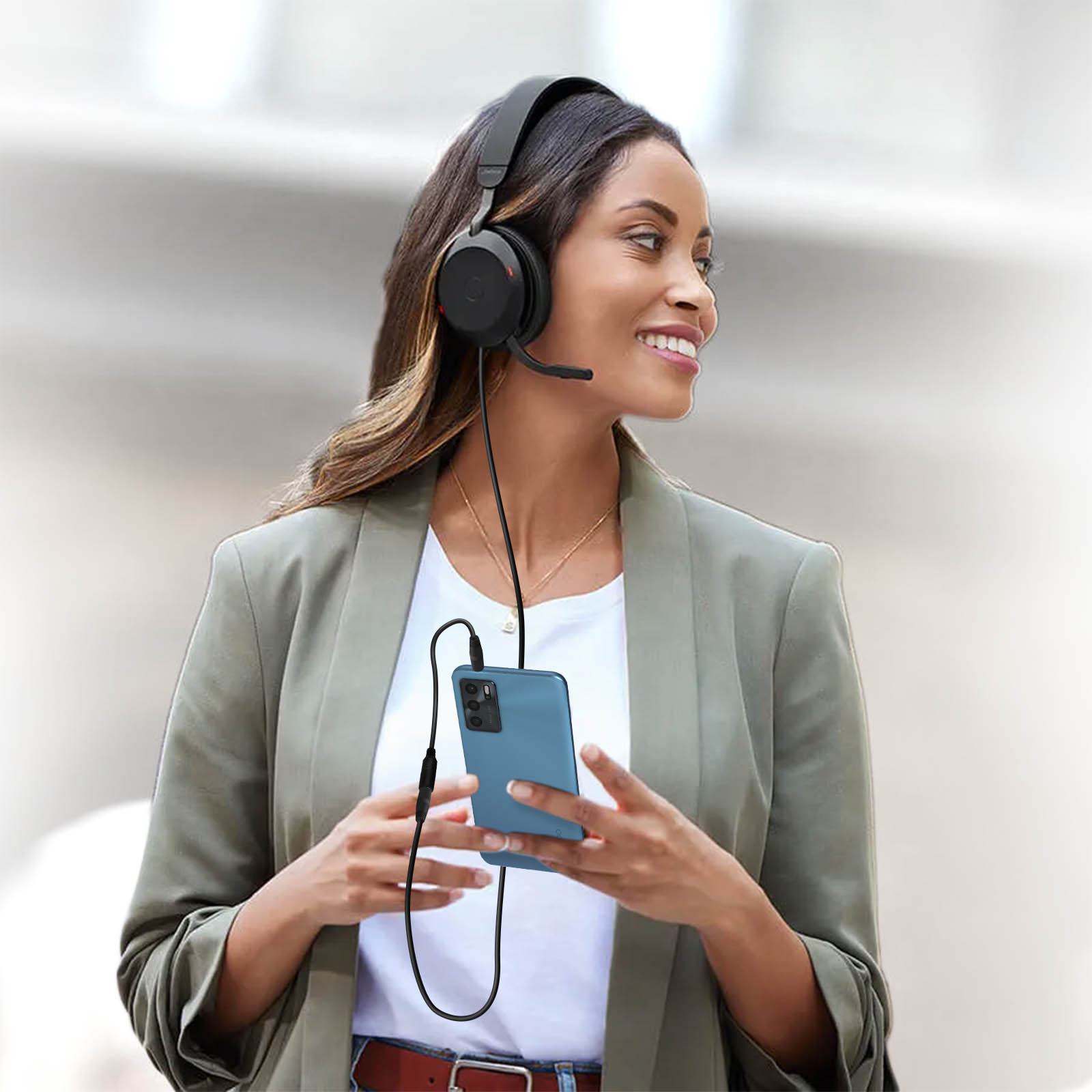 Donna con cuffie e smartphone. Il cavo delle cuffie è collegato al telefono.