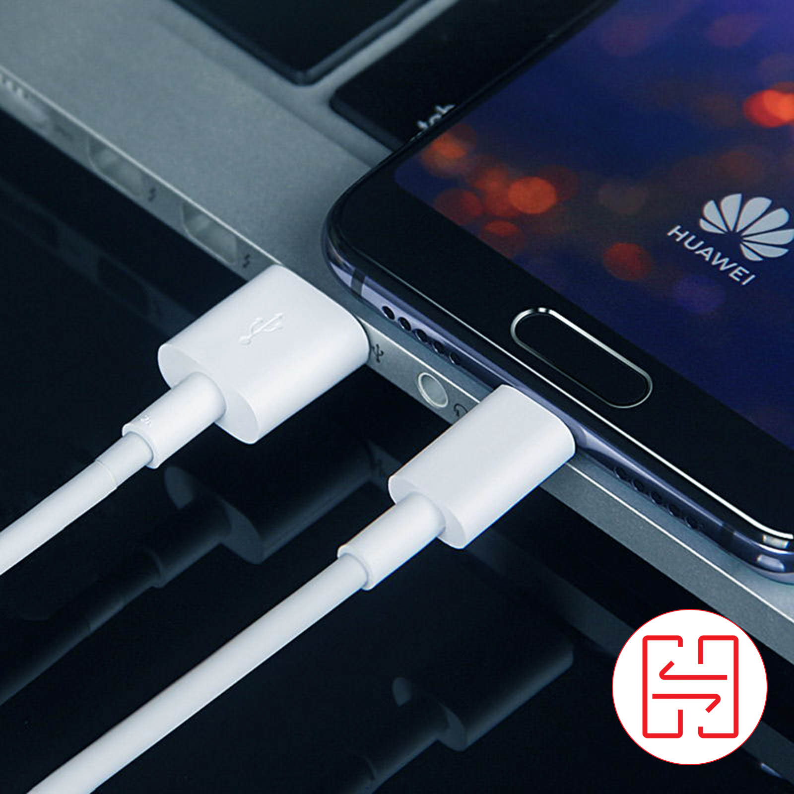 Telefon podłączony do białego kabla USB na klawiaturze laptopa, widoczne logo Huawei.
