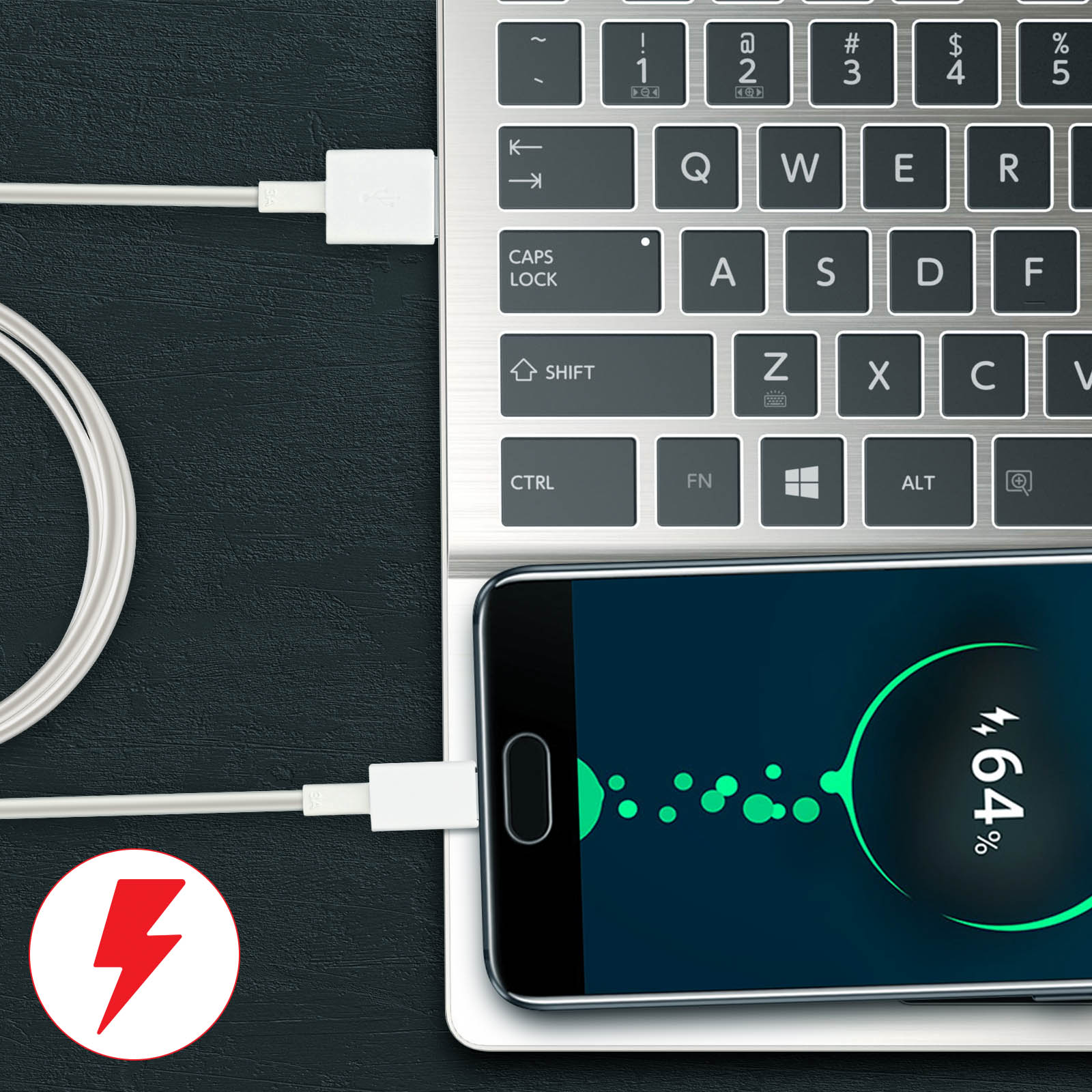 Laptop ładuje telefon z symbolem ładowania, pokazując 64% baterii.