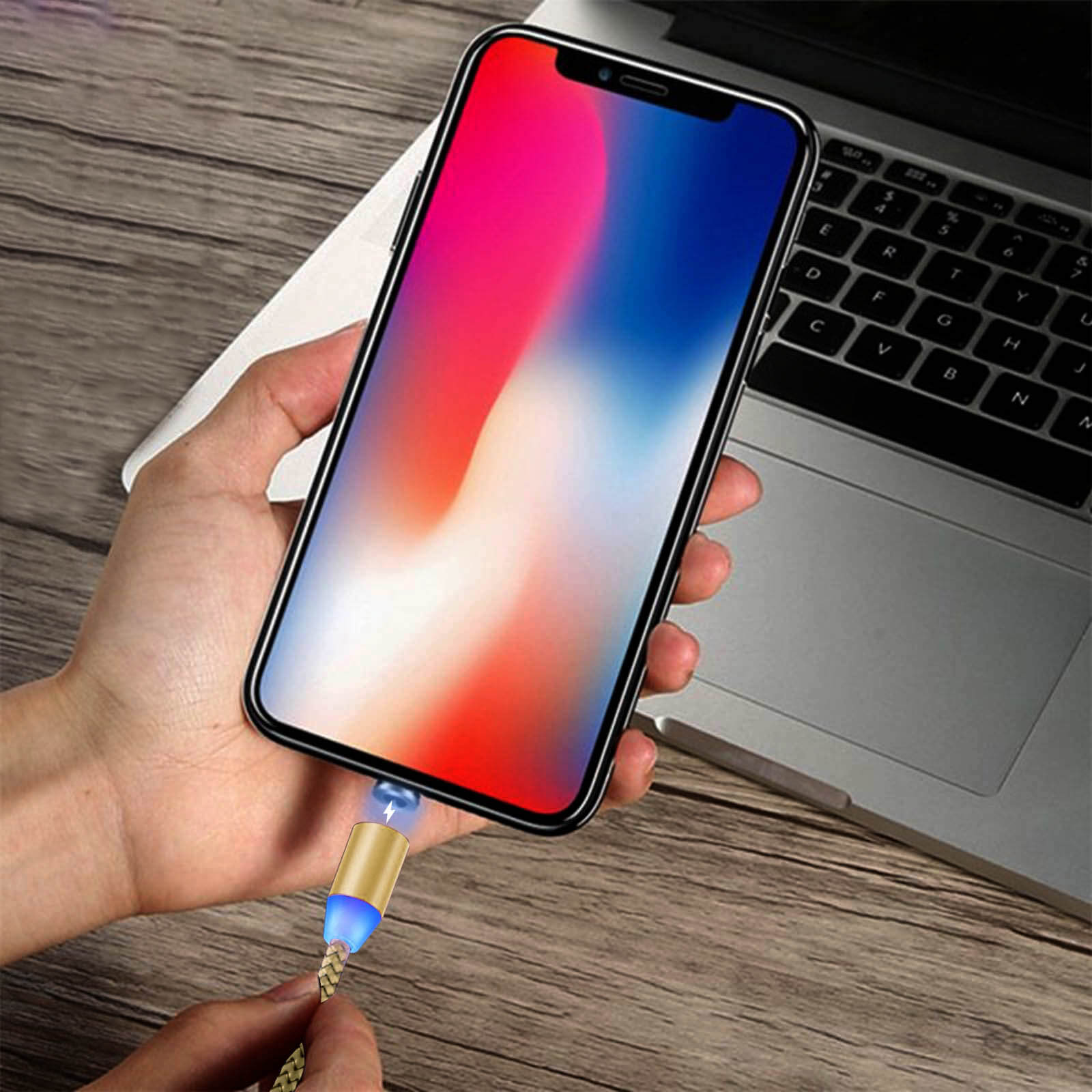 Un telefono si sta caricando con un cavo magnetico. Il telefono e il cavo sono su una superficie di legno.