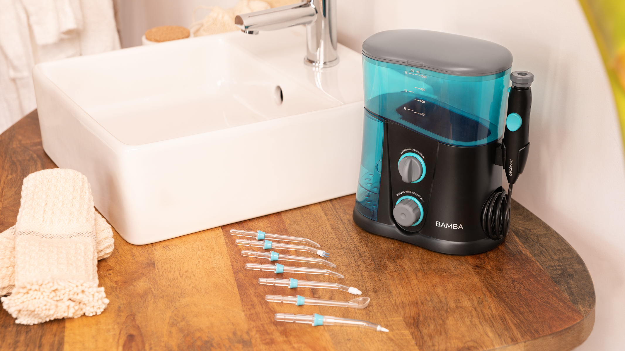 Waterflosser op een houten oppervlak naast een wastafel en accessoires.