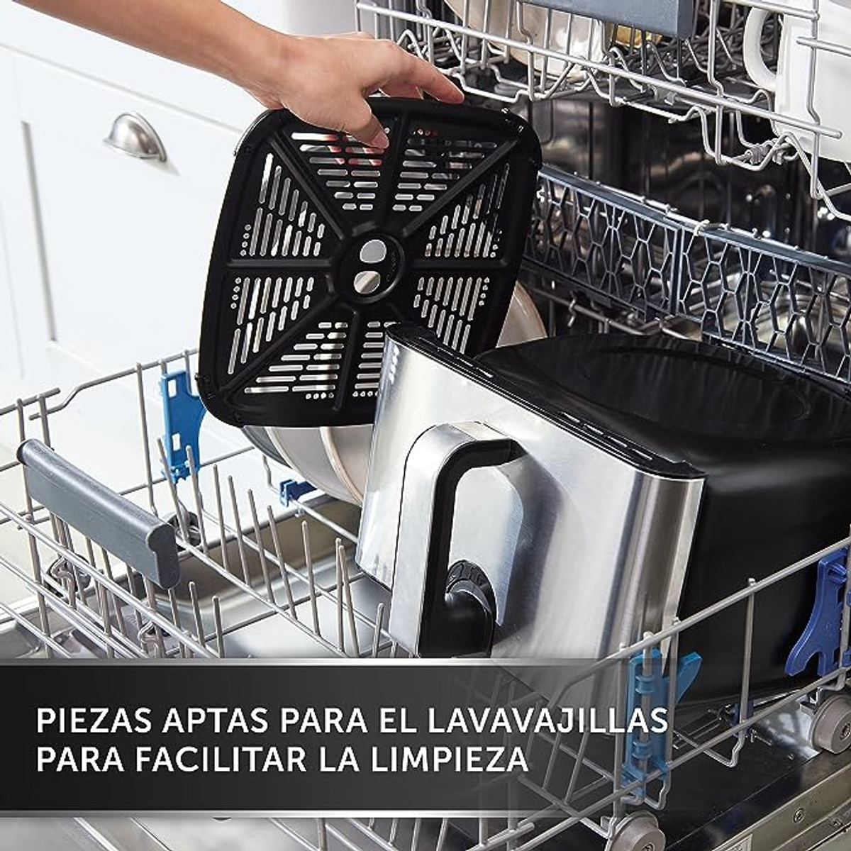 Lavavajillas con objetos dentro. Se está colocando una cesta negra de freidora de aire.