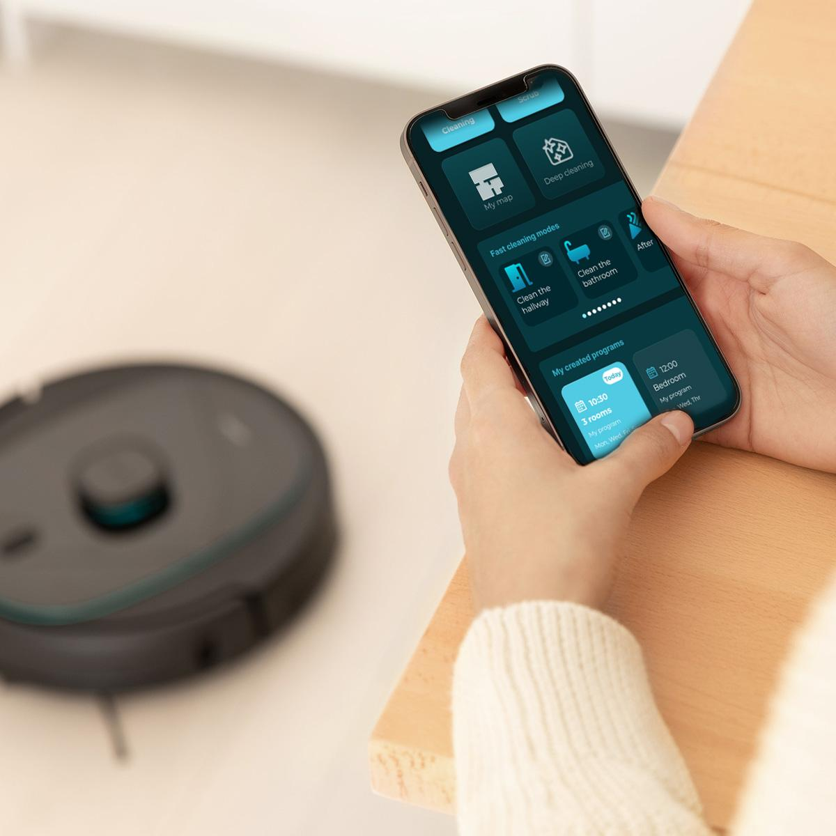 Mains d'une personne tenant un smartphone affichant une interface d'application de nettoyage.