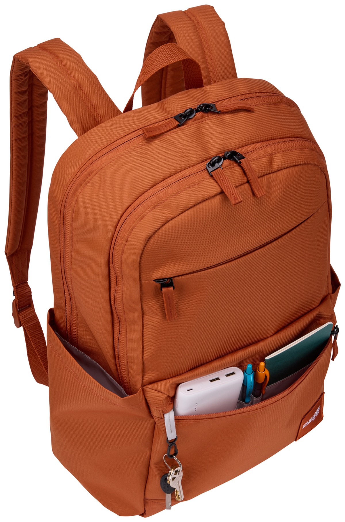 Oranger Rucksack gefüllt mit Gegenständen. Powerbank, Stifte, Schlüssel und Notizbuch sind sichtbar.