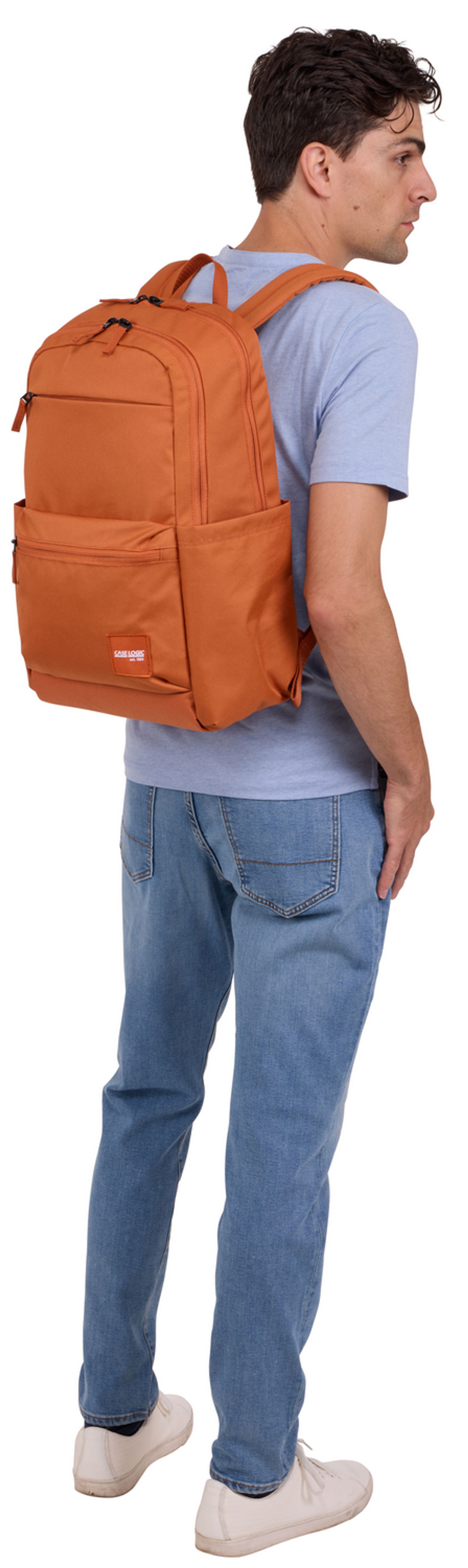 Mann mit Rucksack. Er trägt Jeans und blaues Hemd. Weißer Hintergrund.