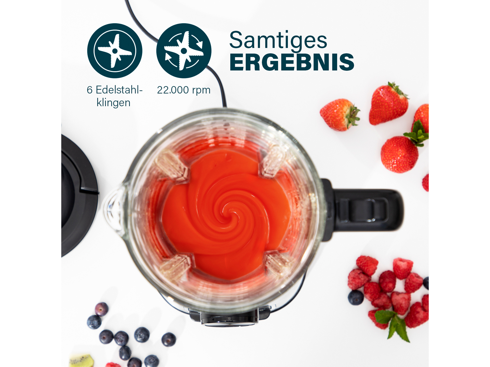 Frullatore con contenuto rosso, circondato da frutti di bosco e fragole. Sfondo bianco.