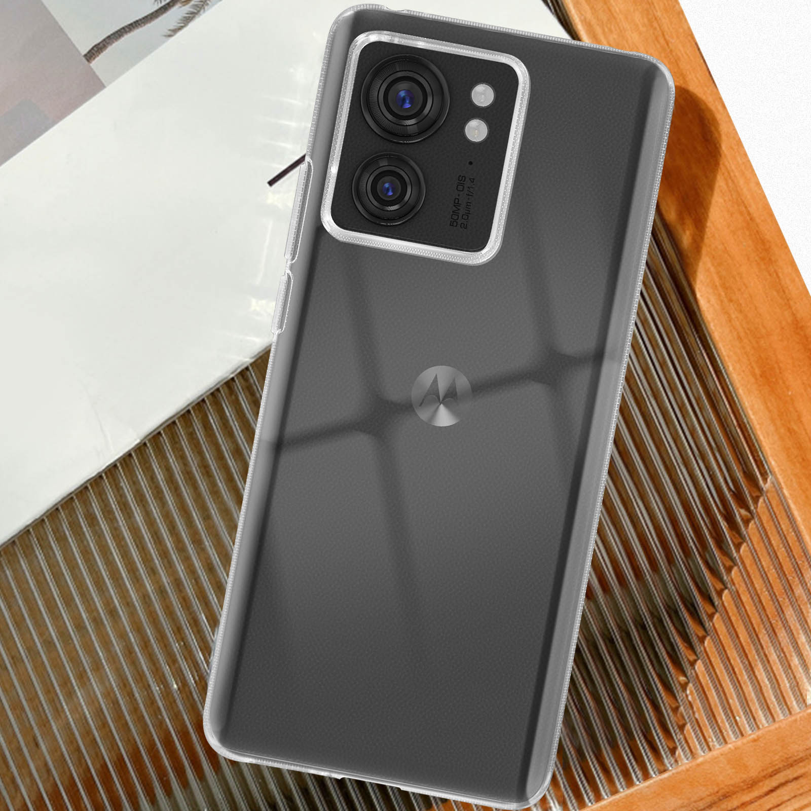 Ein Smartphone in einer durchsichtigen Hülle, das ein Kameramodul zeigt. Das Telefon liegt auf einer Holzoberfläche.
