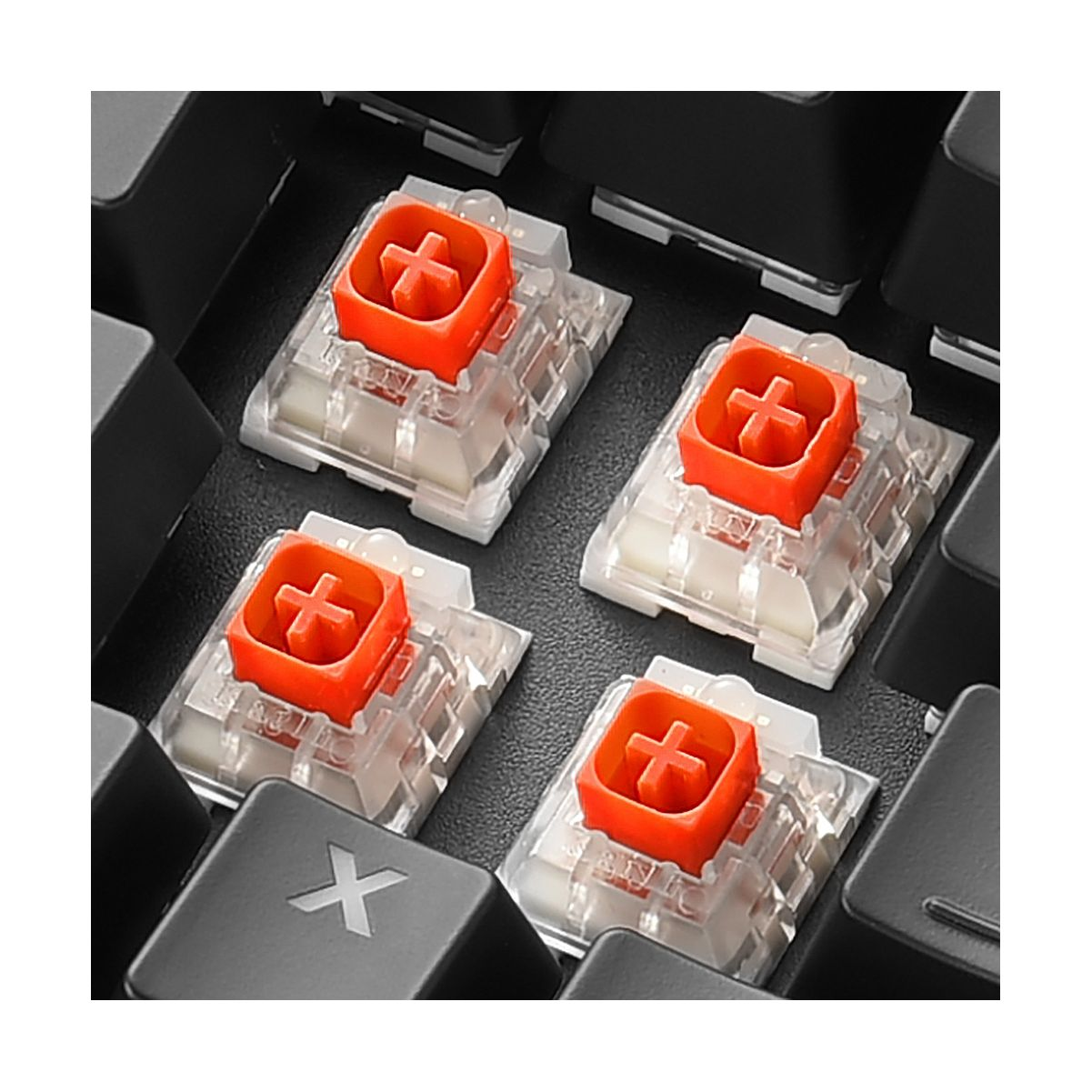Zbliżenie przełączników klawiatury mechanicznej, każdy z pomarańczowym krzyżem i przezroczystym korpusem.