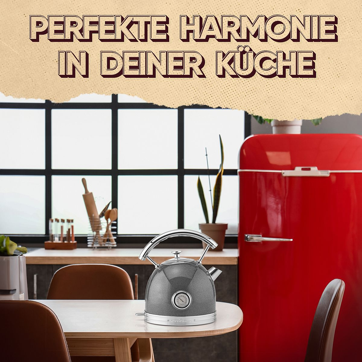 Szary czajnik na stole w kuchni z czerwoną lodówką.