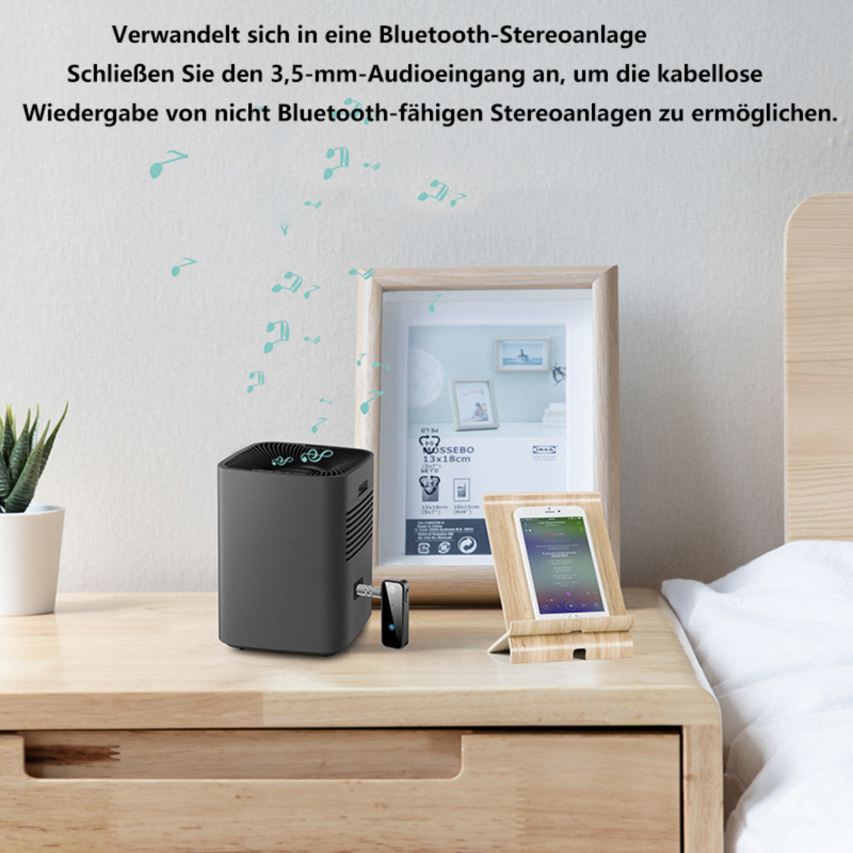 Un altavoz negro con un soporte para teléfono en una mesa de madera. Notas musicales en la pared.