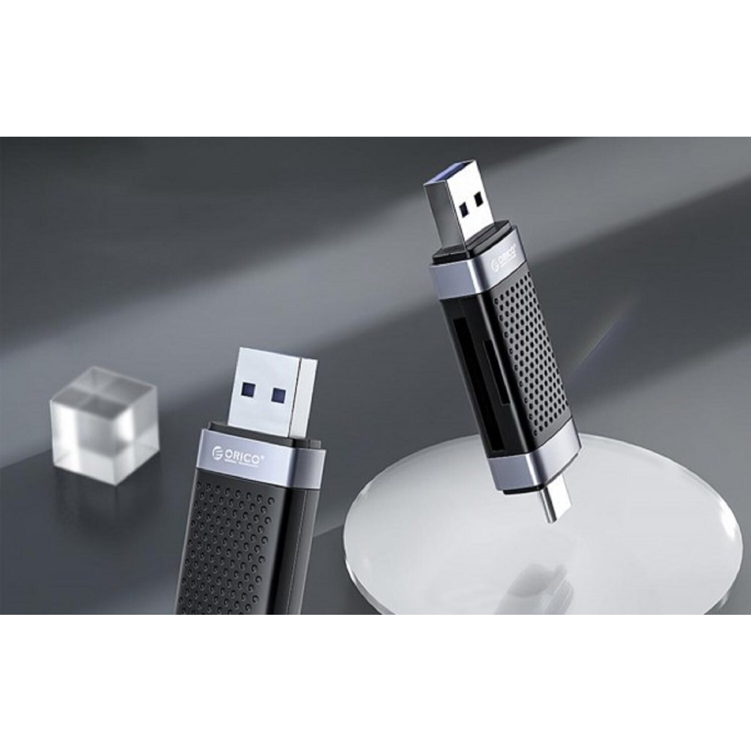 Due chiavette USB, una in uso, una che mostra il marchio, su una superficie bianca.