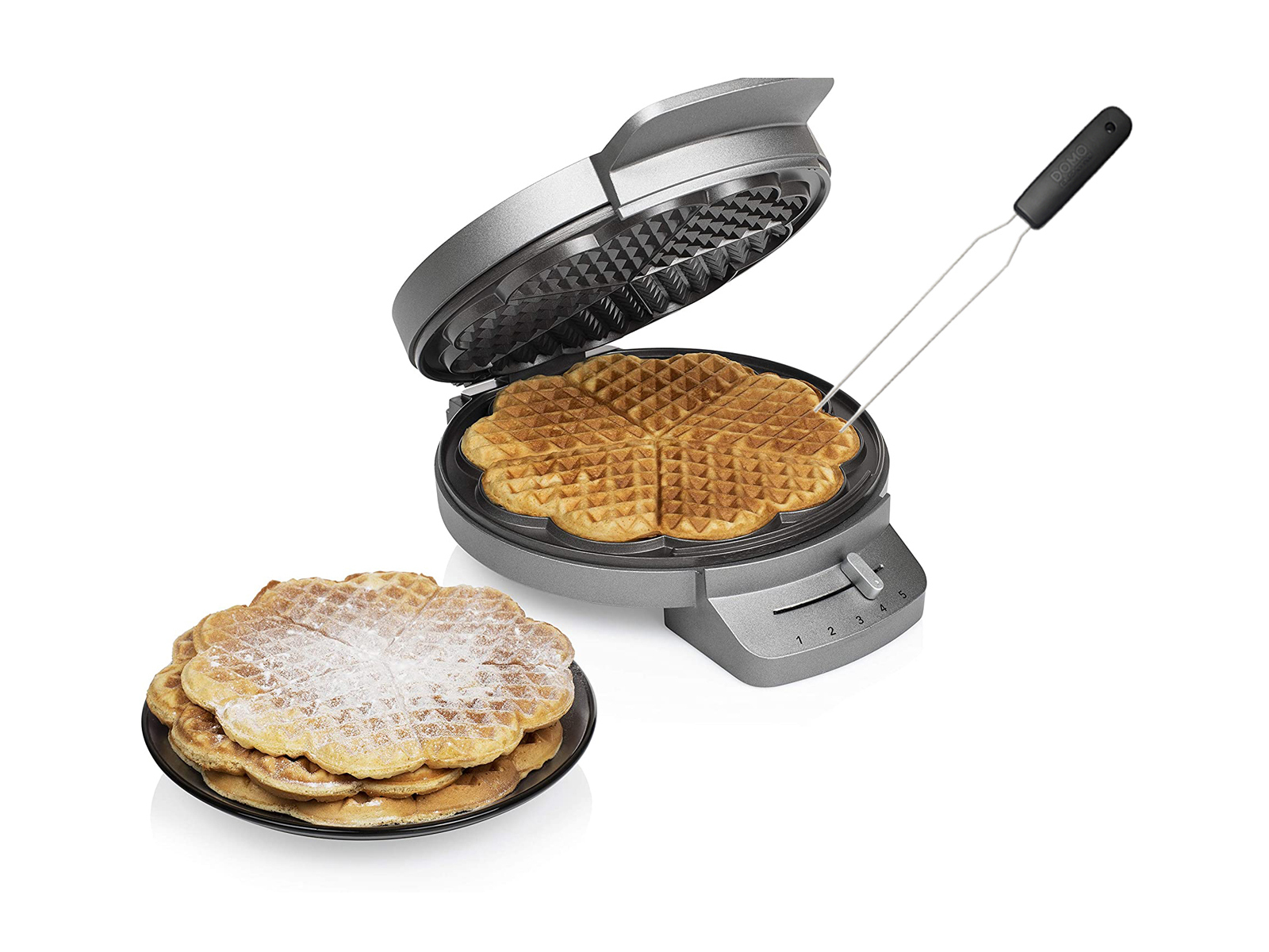 Waffeleisen mit Waffeln und Waffeln auf einem Teller, einige mit Zucker bestäubt.