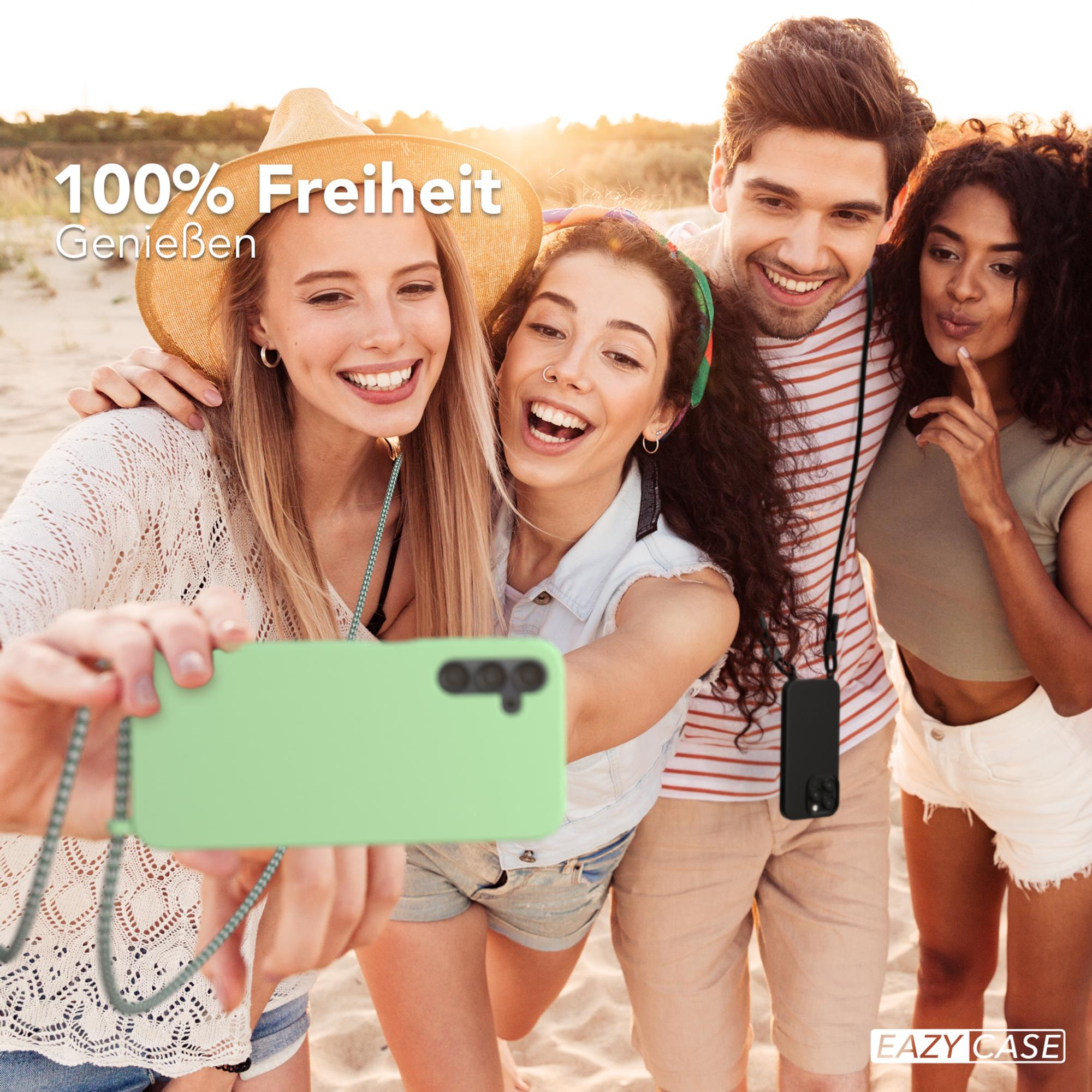 Vier Freunde machen ein Selfie am Strand, mit grüner Handyhülle und Lanyard.