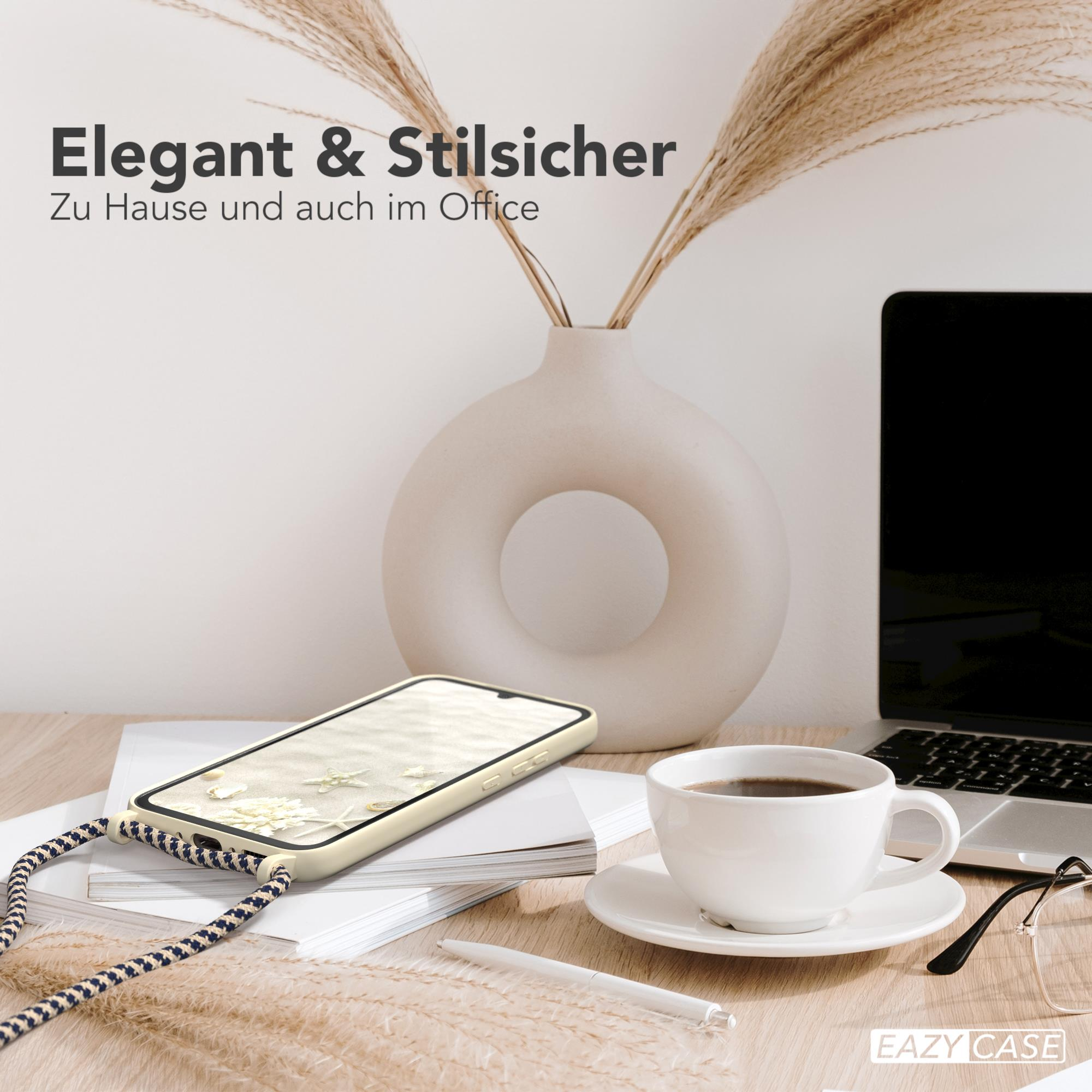 Ein Schreibtisch mit Telefon, Kaffeetasse und Laptop. Eine Vase mit Pampasgras ist vorhanden.
